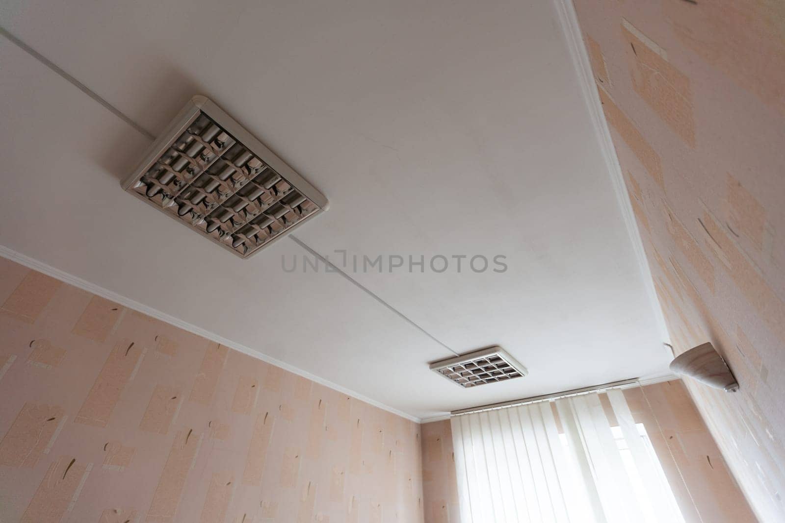 Texture or background, wallpaper of a white celing with daylight lamps in a public institution during the day. High quality photo