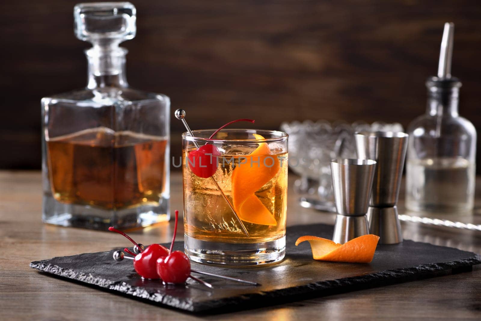 Cocktail Old Fashioned is an old-fashioned sophistication of whiskey and sweet syrup. Served with ice, orange zest and Maraschino cherry. 