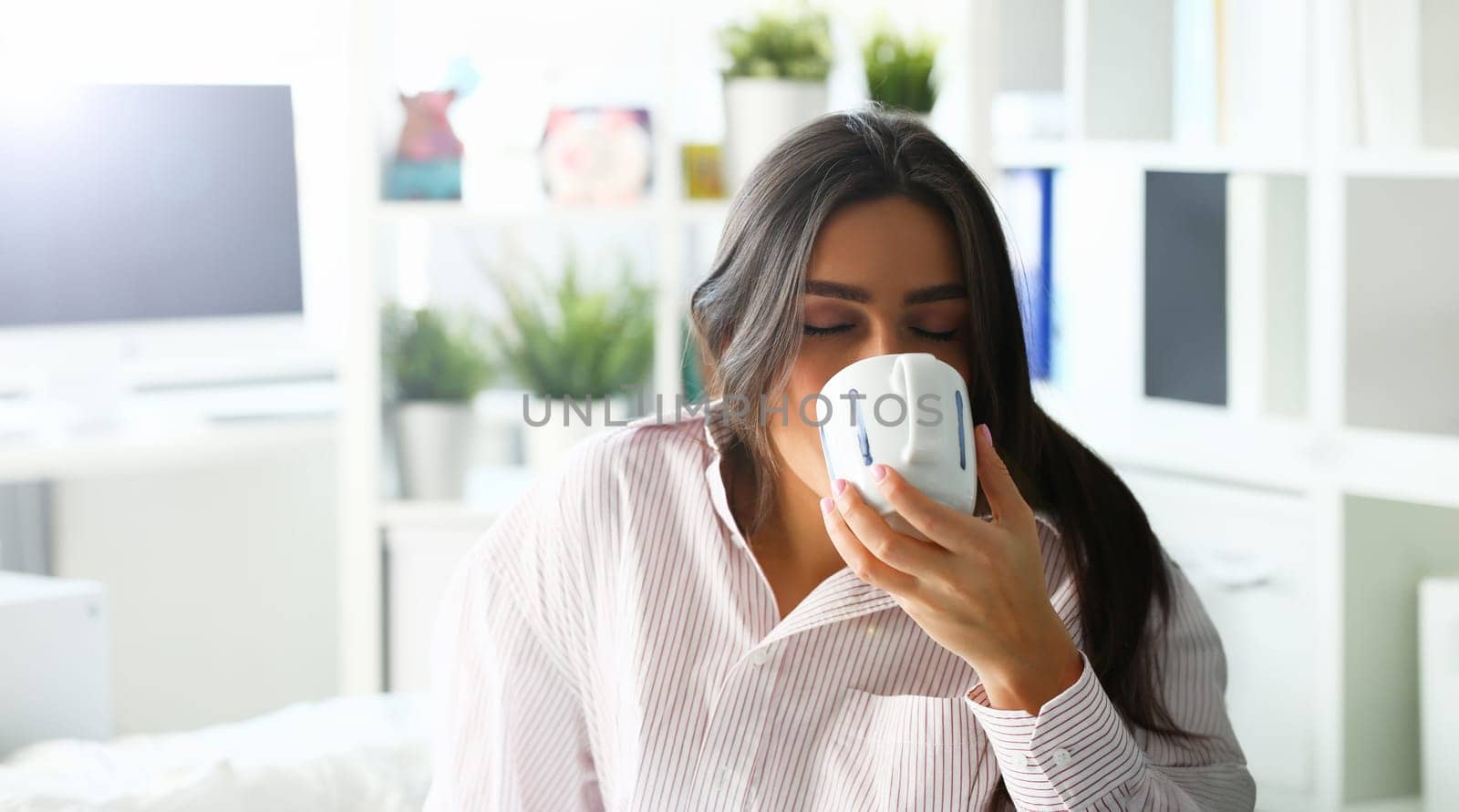 Beautiful woman drink water on bed portrait. Morning holyday sleep concept background.