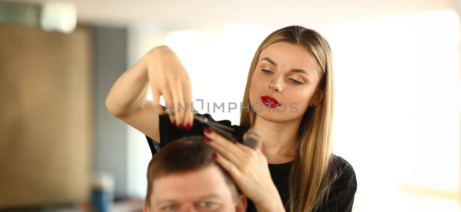 Female Hairstylist Cutting Hair of Man Client by kuprevich