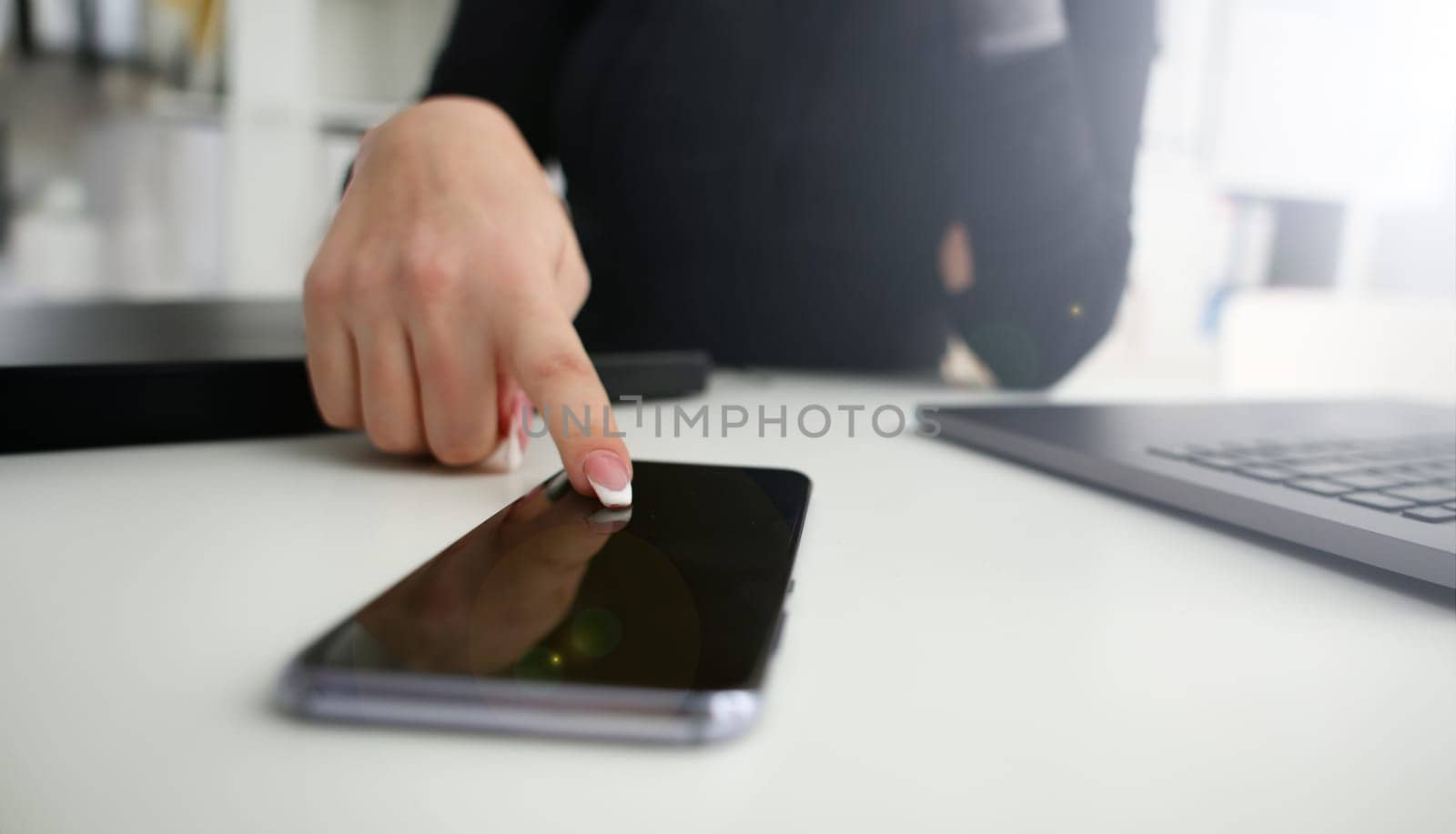 Female arm hold phone and silver pen at workplace closeup by kuprevich