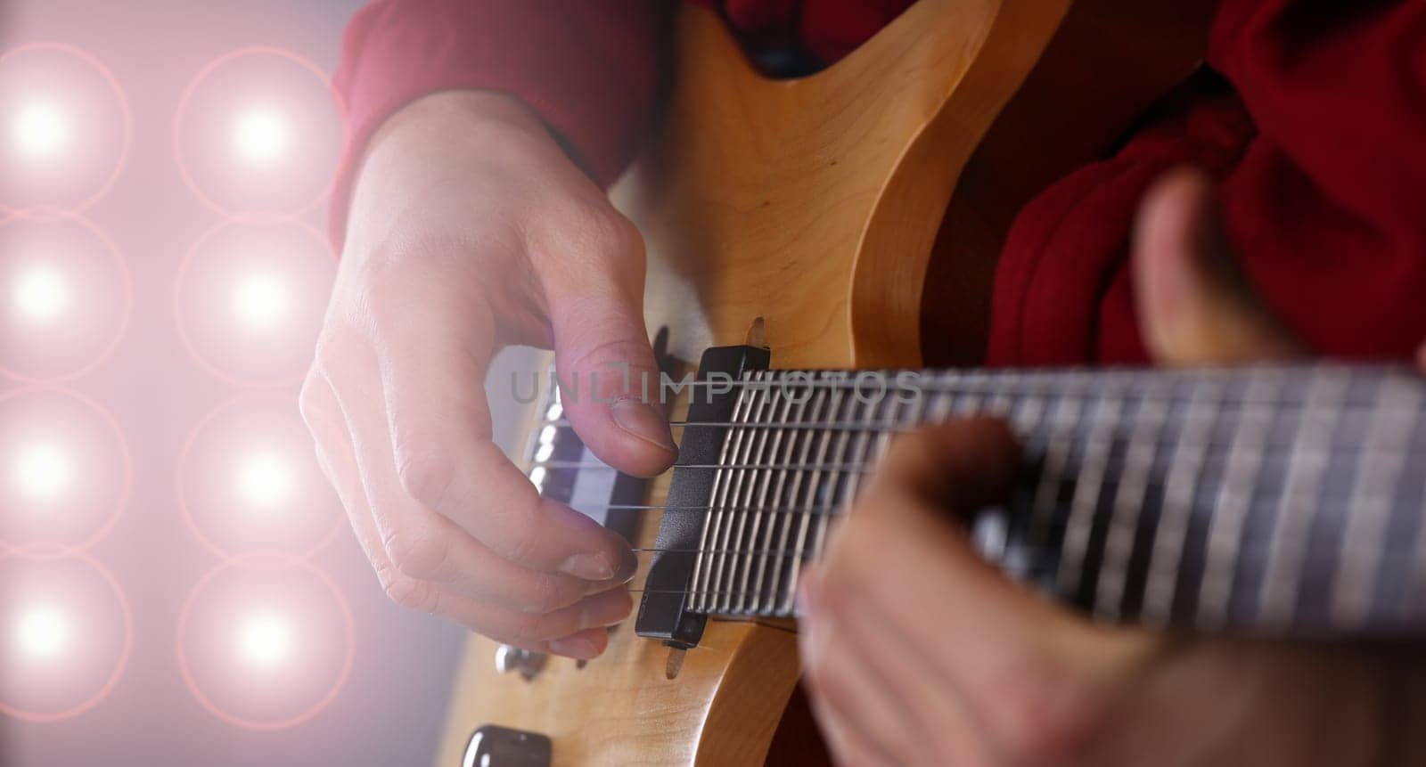 Male arms holding and playing classic shape wooden electric guitar closeup. Six stringed learning musical school education art leisure electrical vintage stage shop having fun enjoying hobby concept