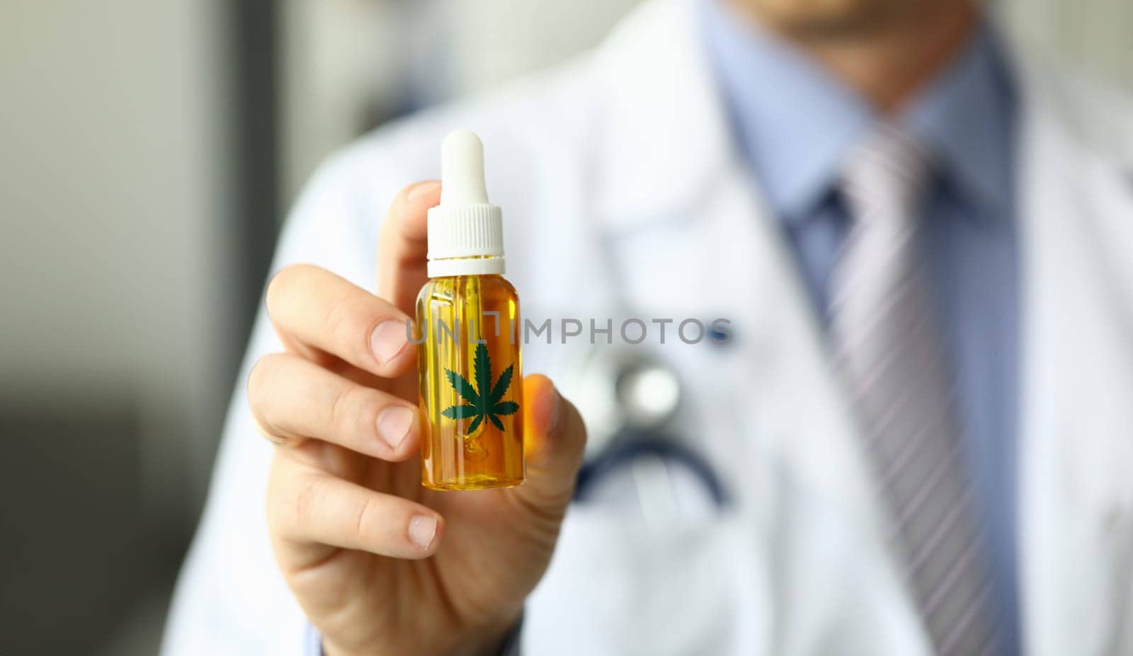 Male doctor hold bottle with marijuana oil by kuprevich