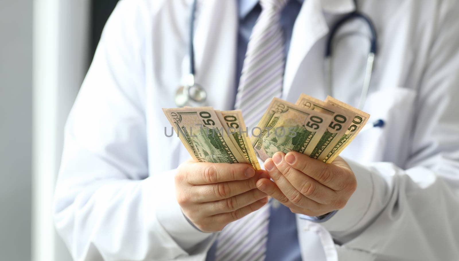 Male hand of doctor hald dollar cash in hand by kuprevich