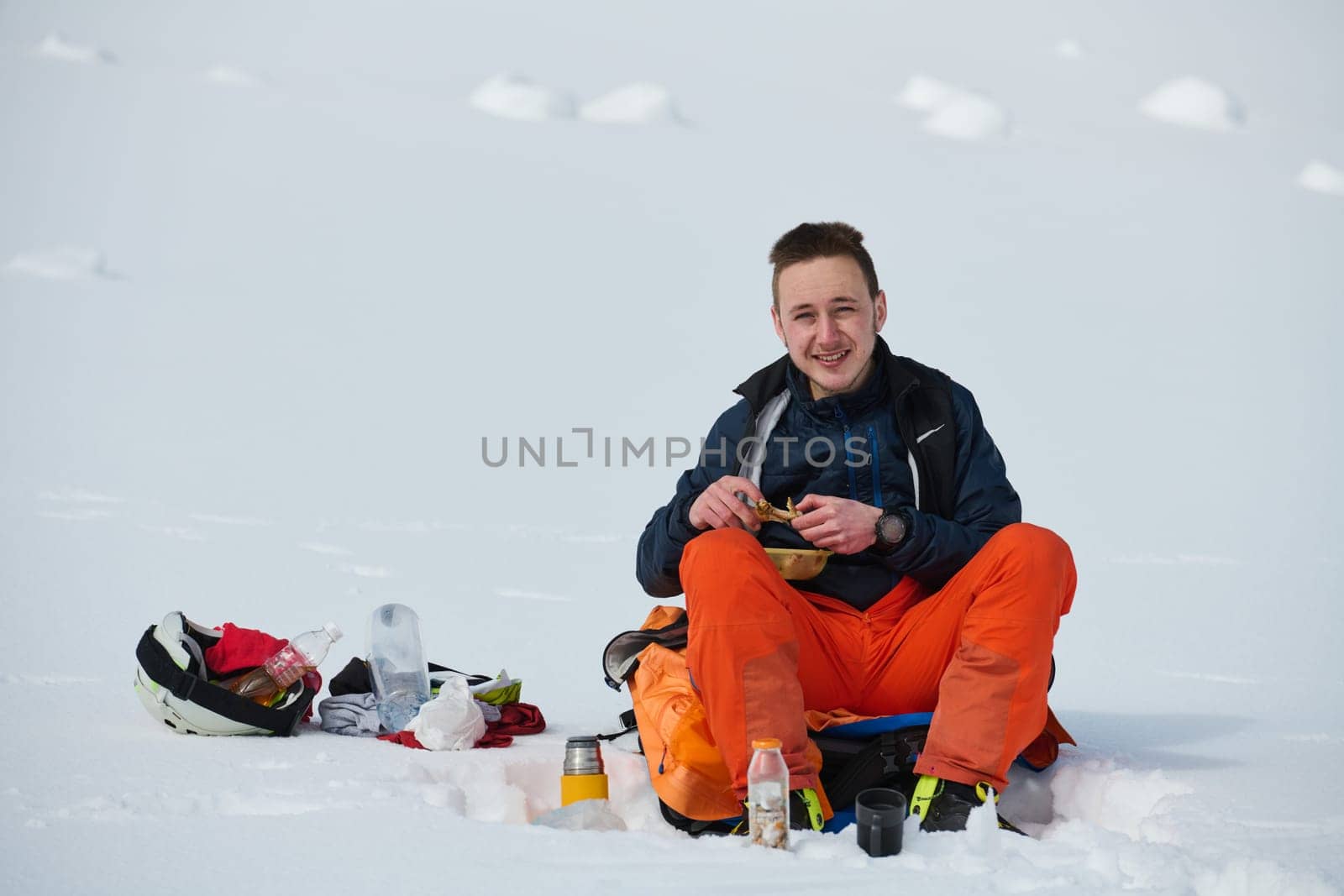 A skier pauses on a snow-capped ridge to savor a moment of peace and take in the breathtaking alpine panorama.