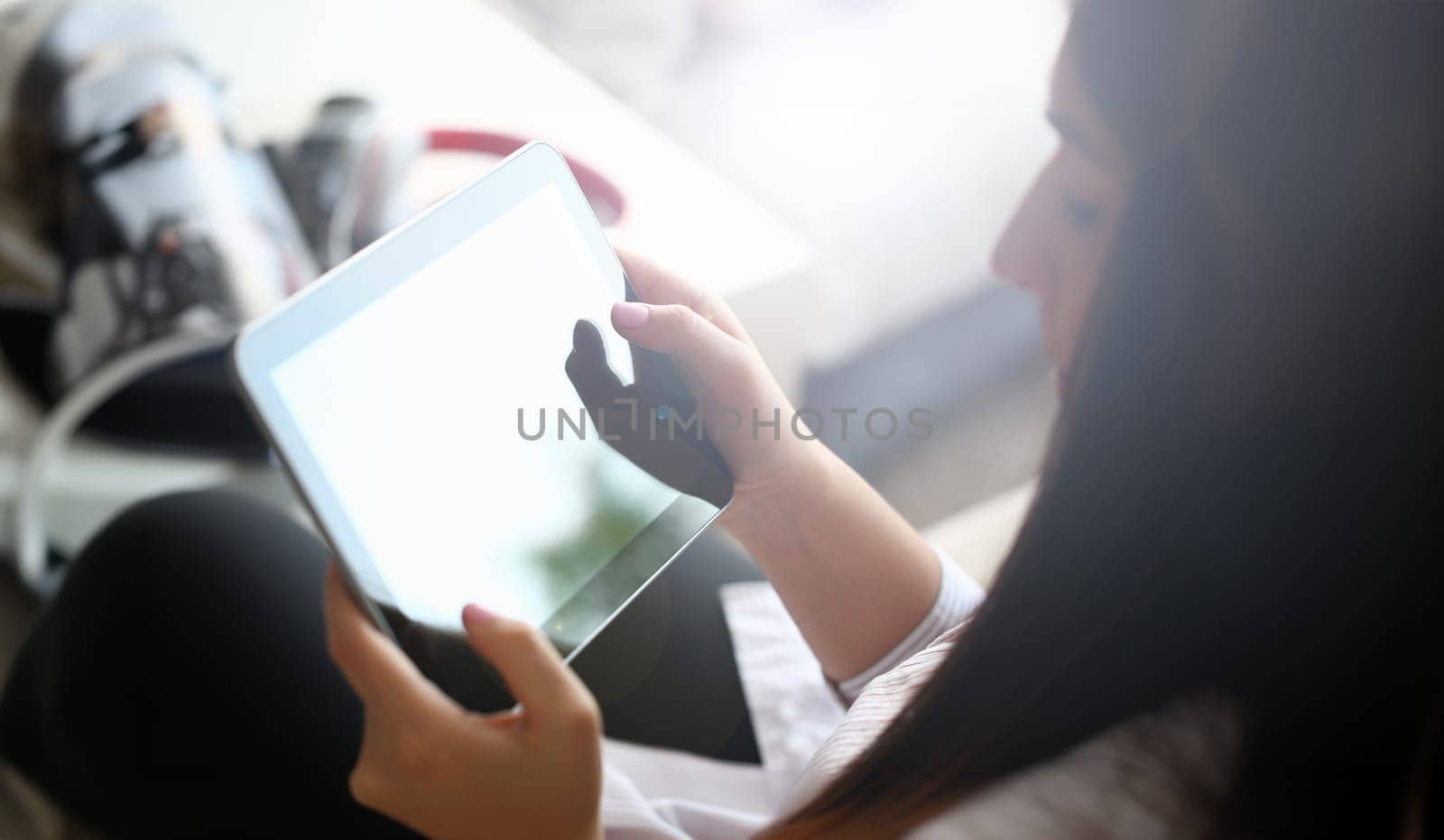female hand holds tablet in home setting while by kuprevich