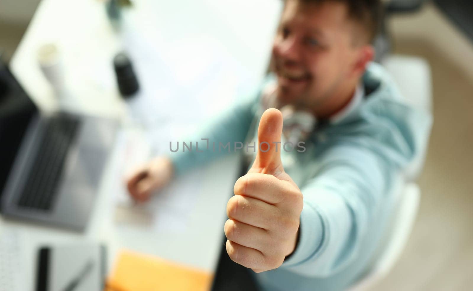 A young designer holds pen from tablet in hand working on new project for customer in field of building construction projects.