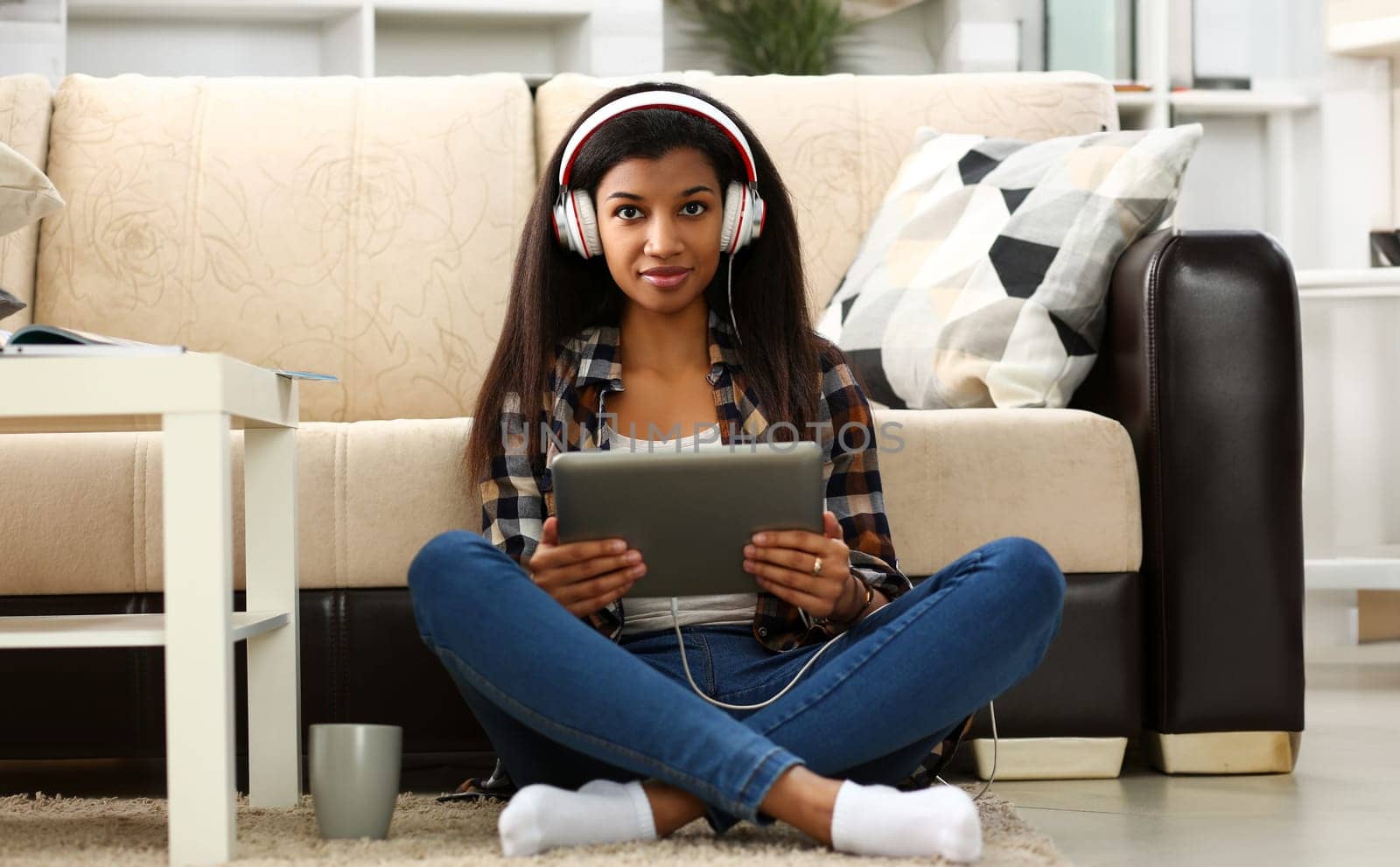 Black ordinary female american teen portrait at home sofa remote education concept. Girl hold tablet in hand music apps teacher checks homework online university library learning foreign languages
