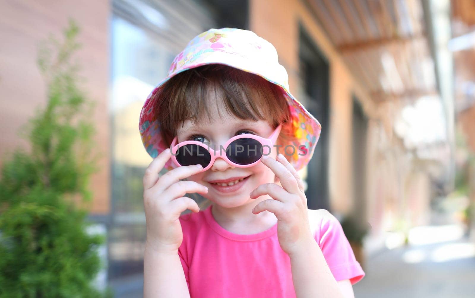 Happy smiling girl child in sunglasses outdoor portrait. Childhood concept.