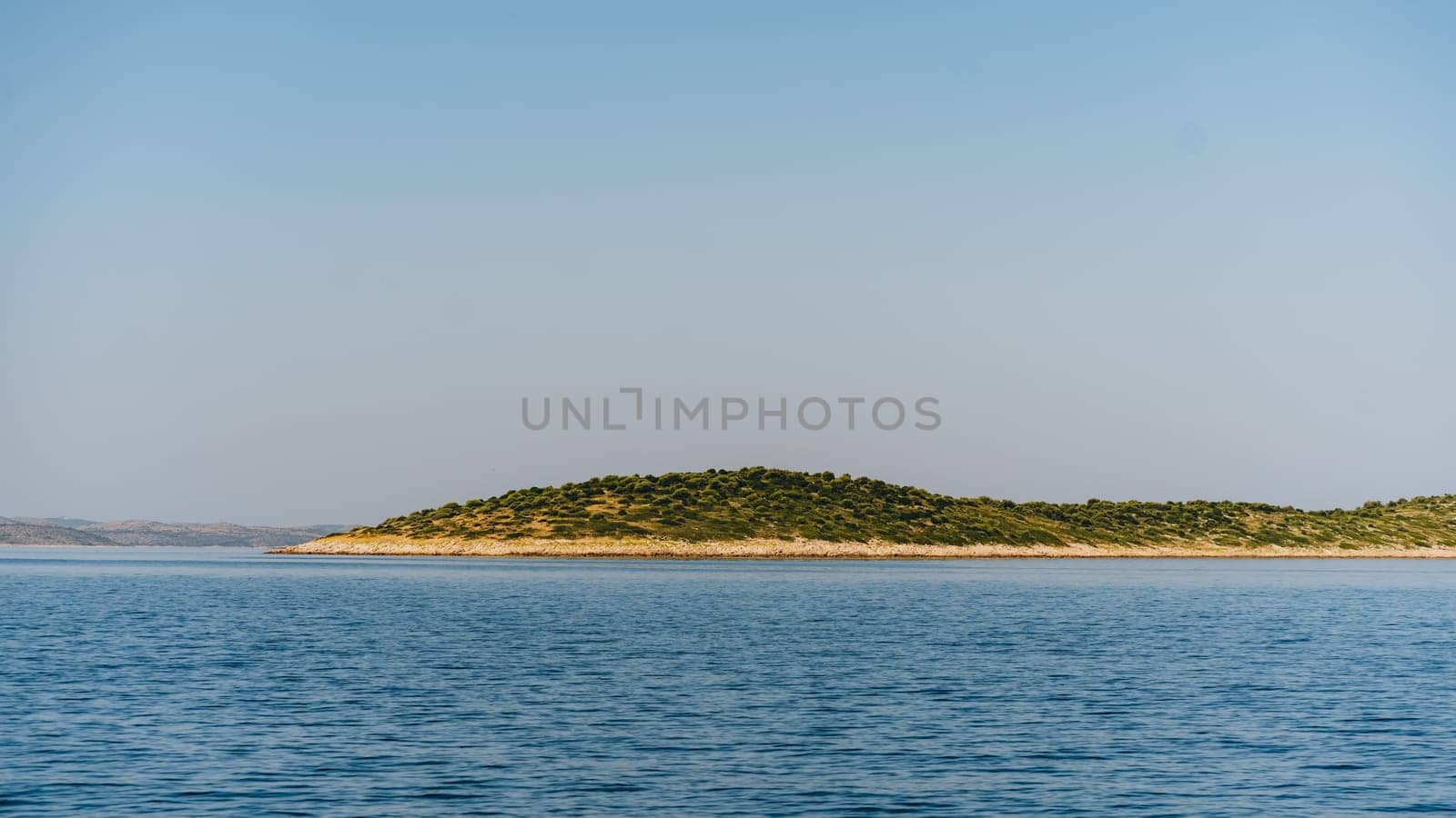 Narrow strip of shore in Dugi Otok island, clear sky and waves of Adriatic Sea, Croatia