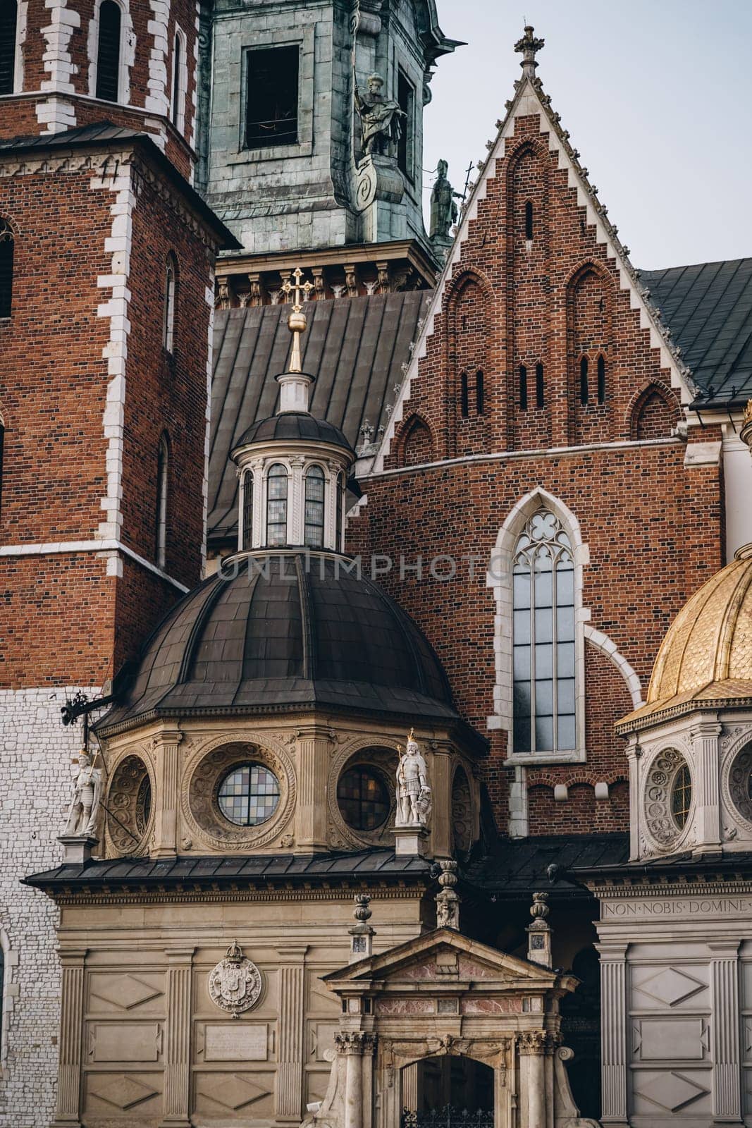 King statue, mosaic lancet and round windows and decorative columns on walls of Wawel Royal Castle, Krakow, Poland