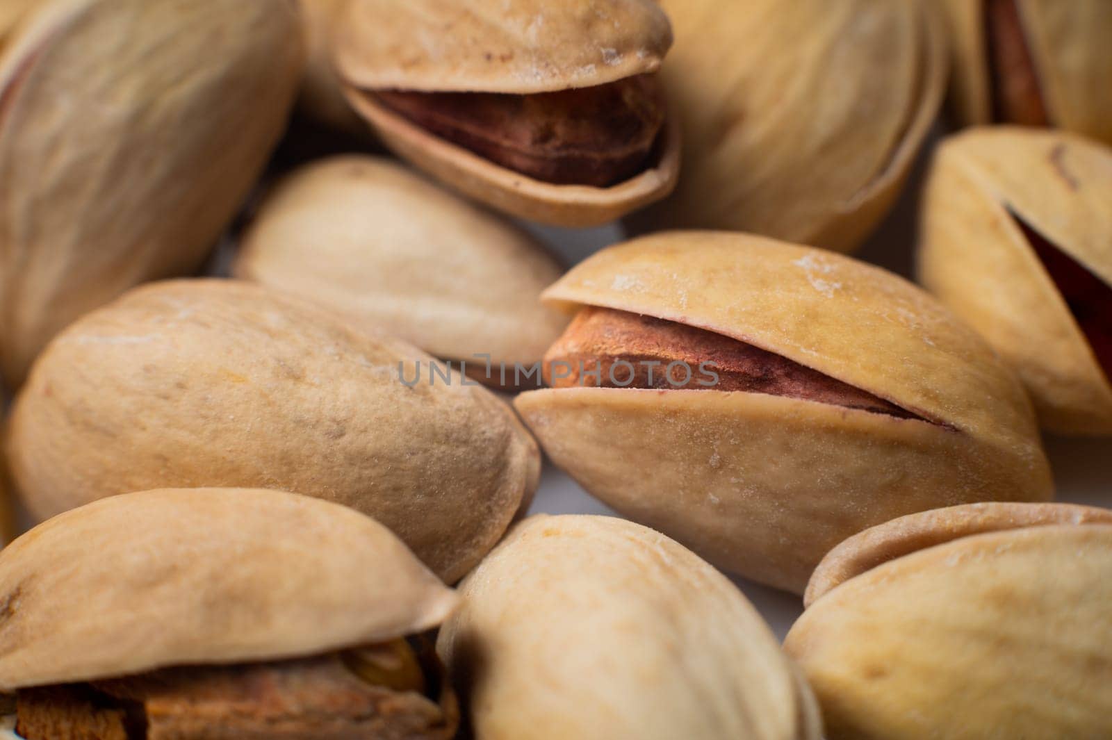 Many closed pistachios in macro close-up. Healthy food background with selective soft focus by yanik88