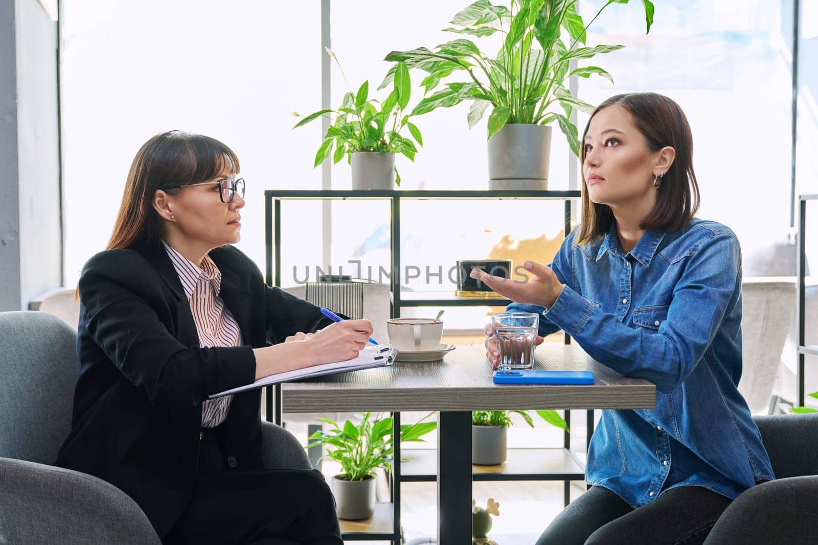 Young female patient at therapy meeting with professional psychologist advisor and mental therapist. Psychology, psychotherapy, counseling, mental assistance, health support