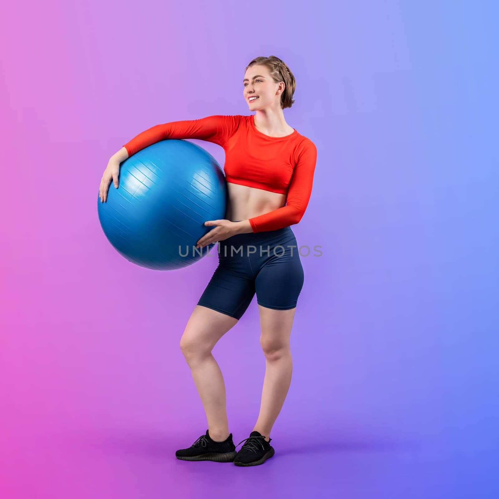 Full body length gaiety shot athletic and sporty young woman with fitness exercising ball in standing posture on isolated background. Healthy active and body care lifestyle.