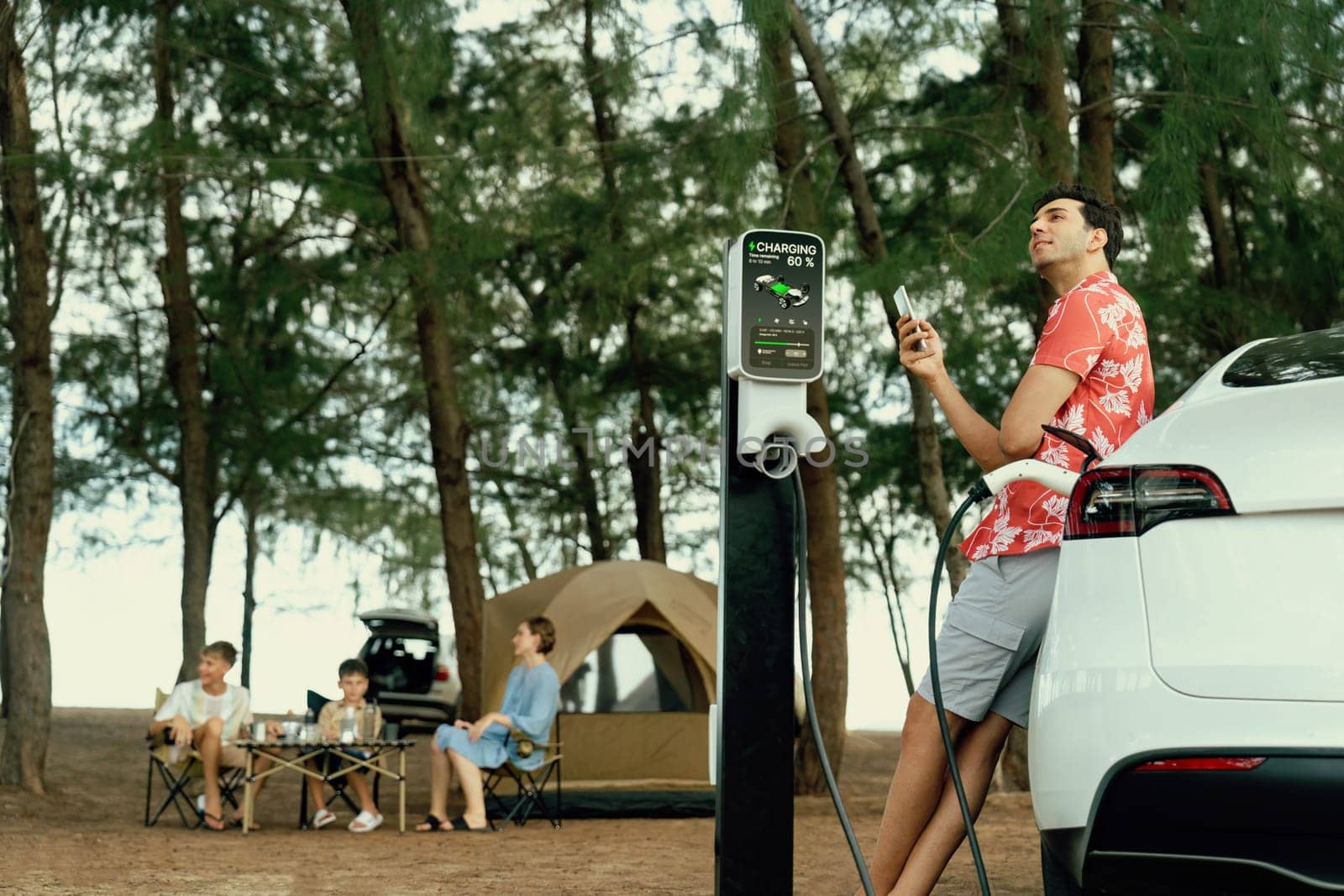 Lovely sit on trunk, charging EV car with EV charging station. Perpetual by biancoblue