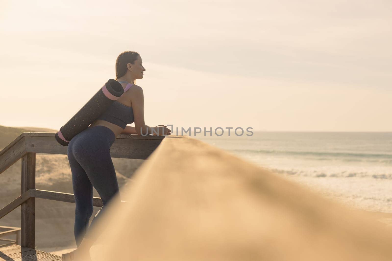 Woman practicing yoga outdoor. Beautiful girl practice asana in online class. Calmness and relax. Background with sunrise
