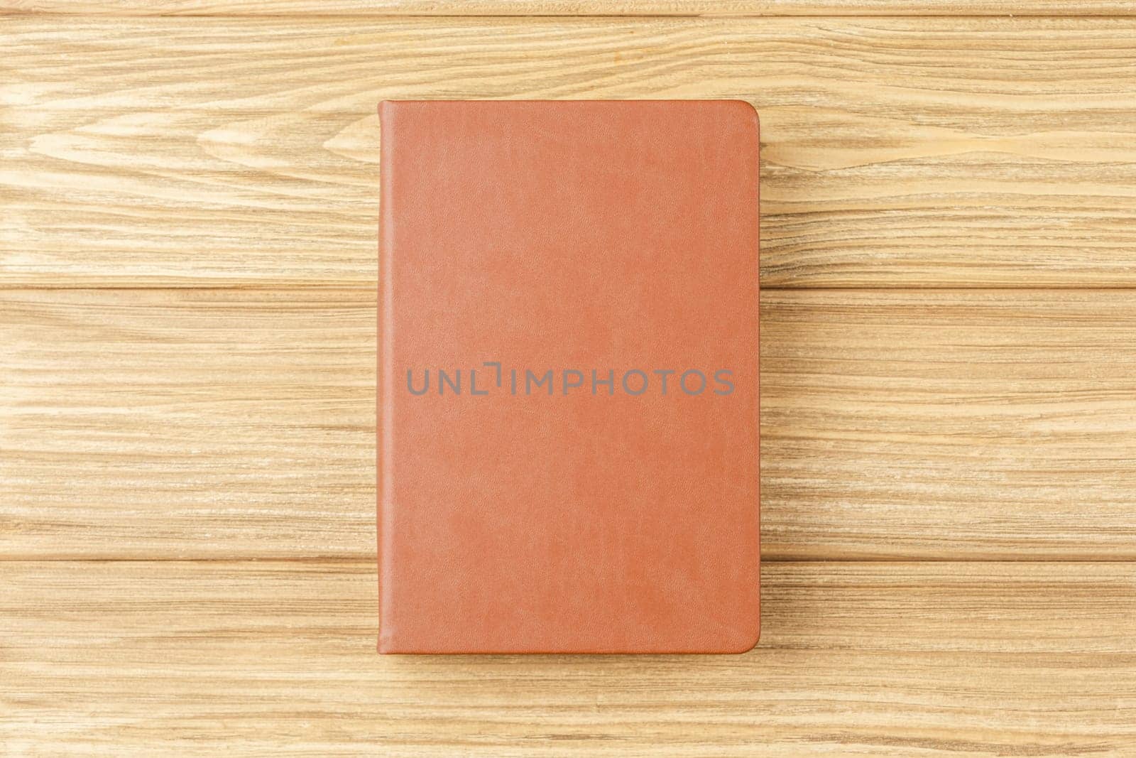 Brown notepad on a wooden background. by alexxndr