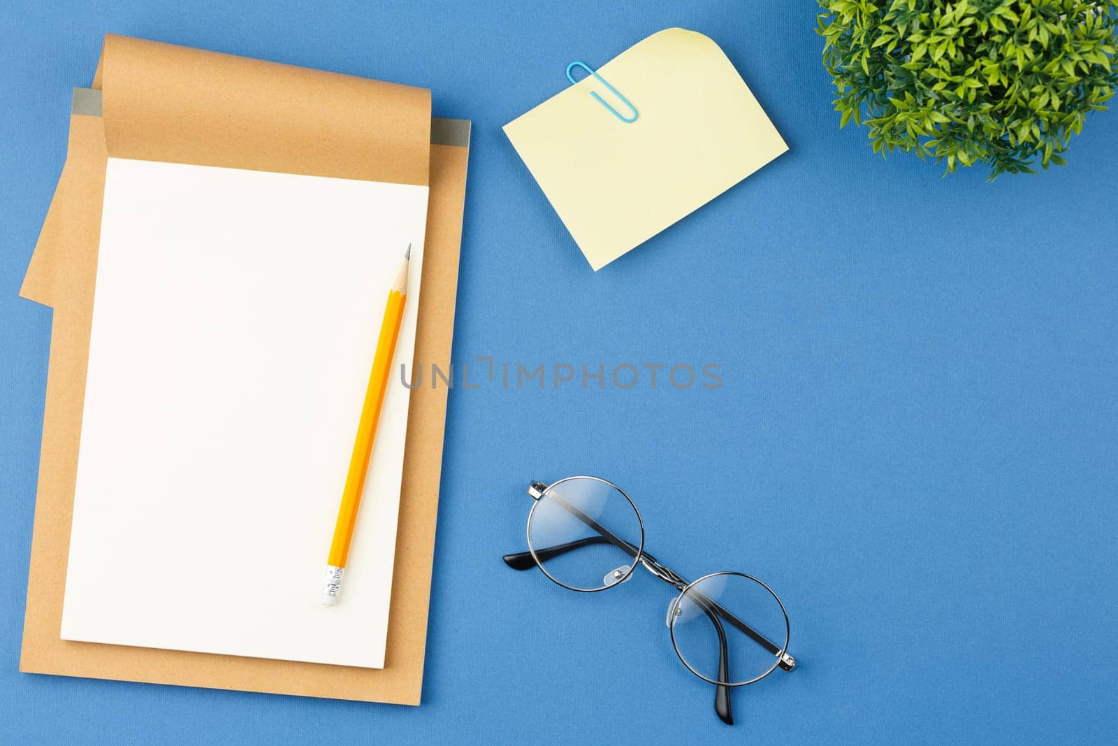 Notepad with pencil, glasses, plant and note sheet by alexxndr