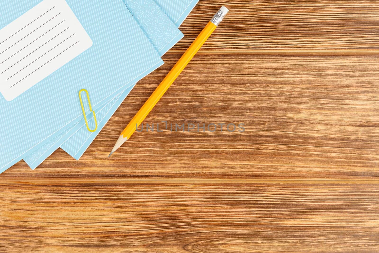 Notebook with a pencil on a wooden background. Study desk. Flat lay. Back to school concept. Top view.