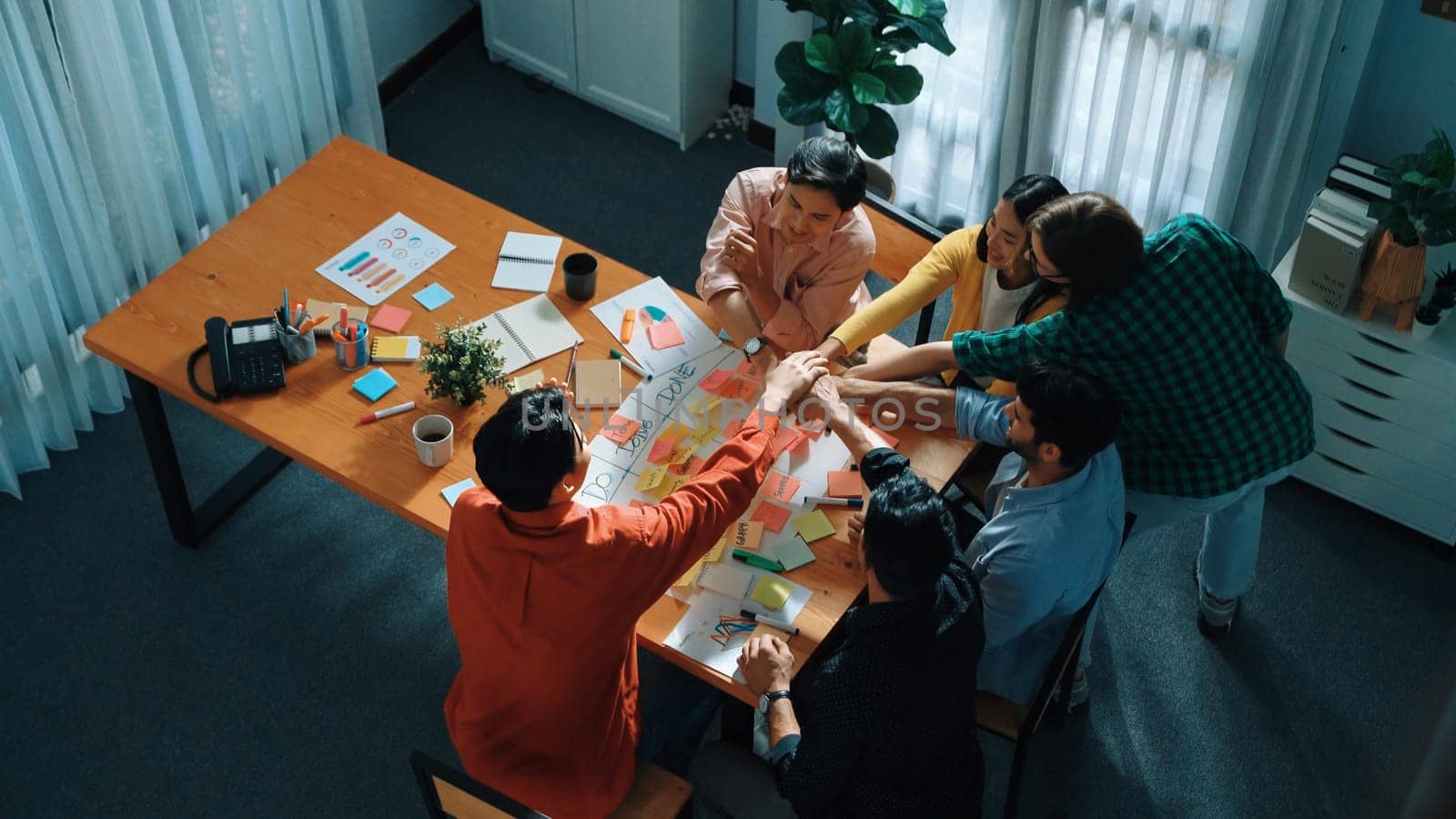 Close up of professional business team hands writing and putting sticky note on scrum task board. Top view of project manager write task and use kanban board to manage time and workflow. Convocation.