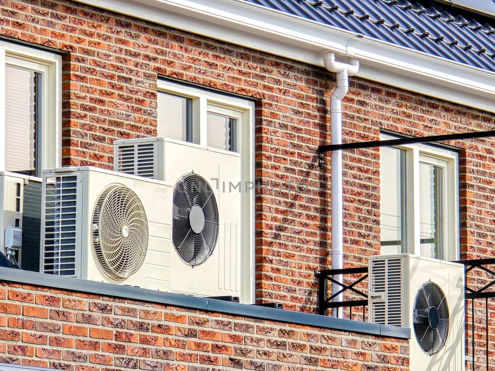 air source heat pump unit installed outdoors at a modern home with solar panels in the Netherlands by fokkebok