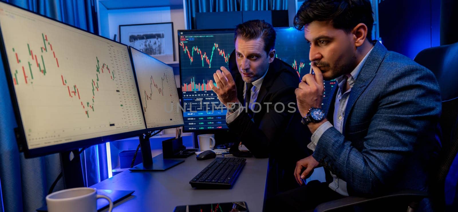 Stock exchange traders looking on high profit chart investment in panorama view, analyzing on monitor at night. Concept of discussing financial technology growth in neon light at workplace. Sellable.