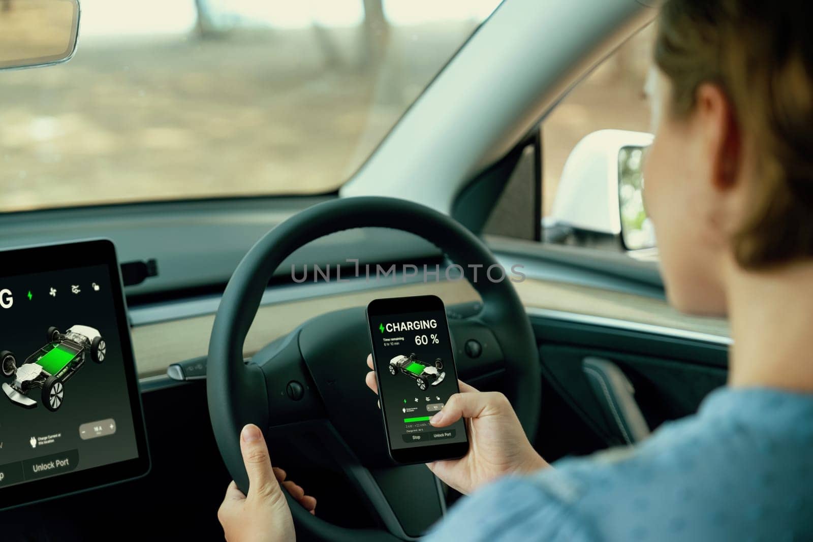 Holiday vacation road trip with environmental-friendly car concept. Eco-conscious woman on driver seat checking EV car's battery status display on tablet or car panel during car travel. Perpetual