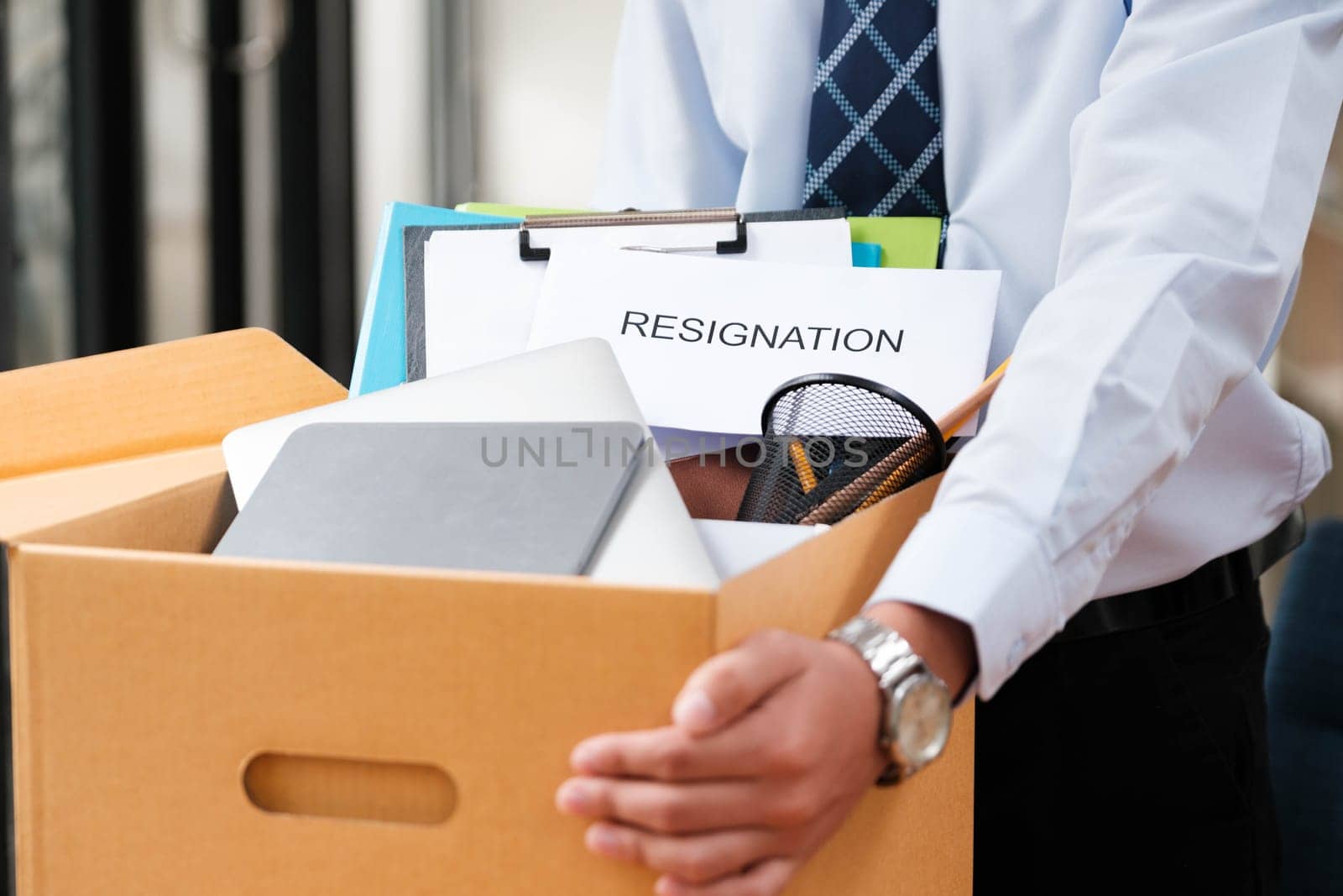 Man places personal items and resignation letter into a box, ending his tenure. by ijeab