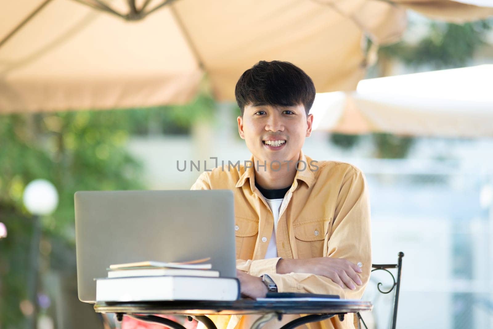 Pensive Student with Laptop Outdoors on University Grounds by ijeab