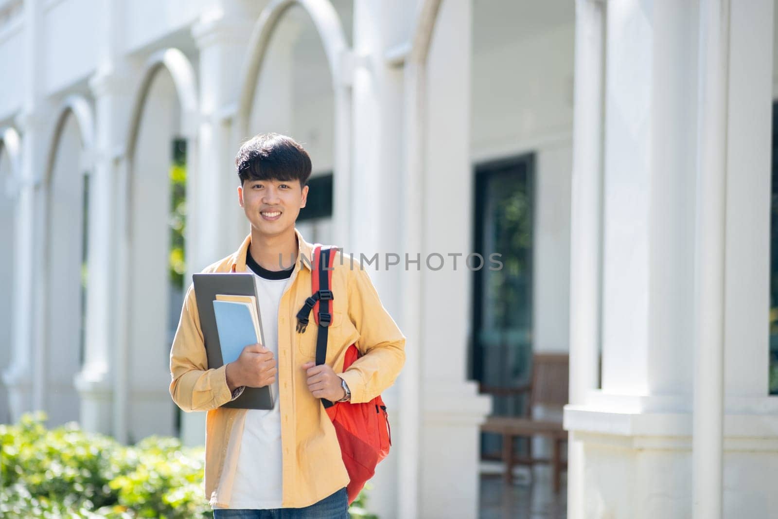 Smiling College Student with Laptop and Books on Campus by ijeab