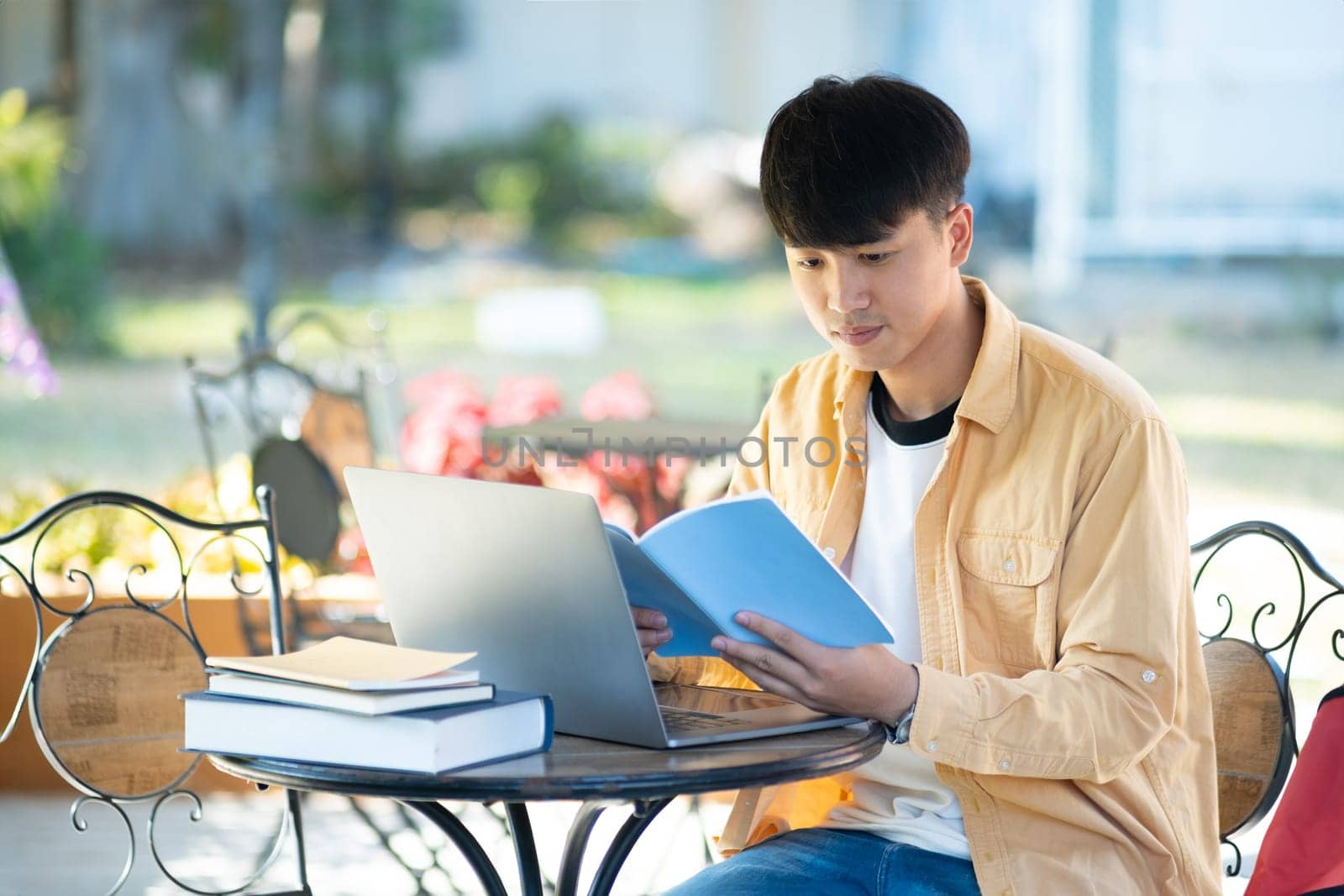 Pensive Student with Laptop Outdoors on University Grounds by ijeab