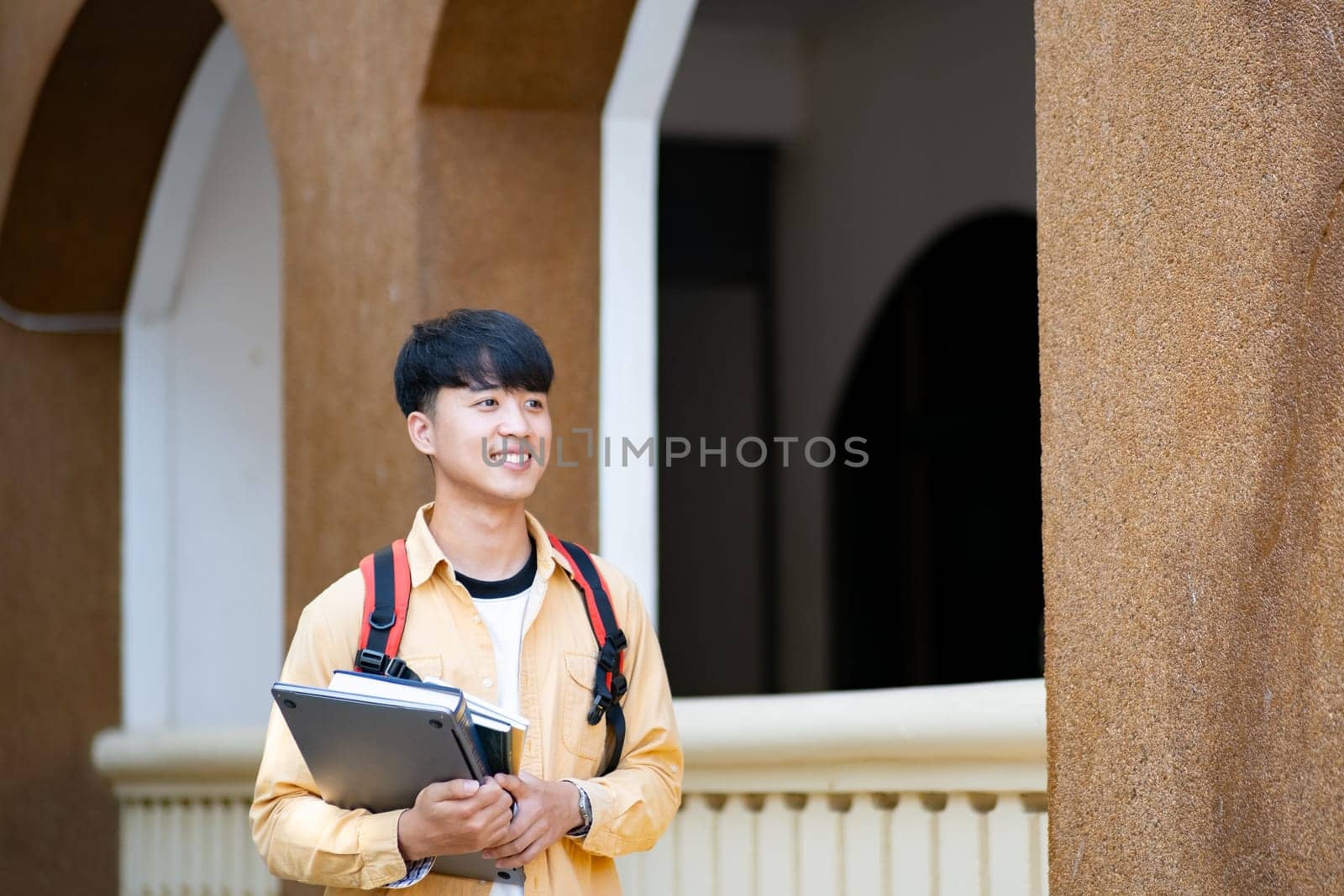 Smiling College Student with Laptop and Books on Campus by ijeab