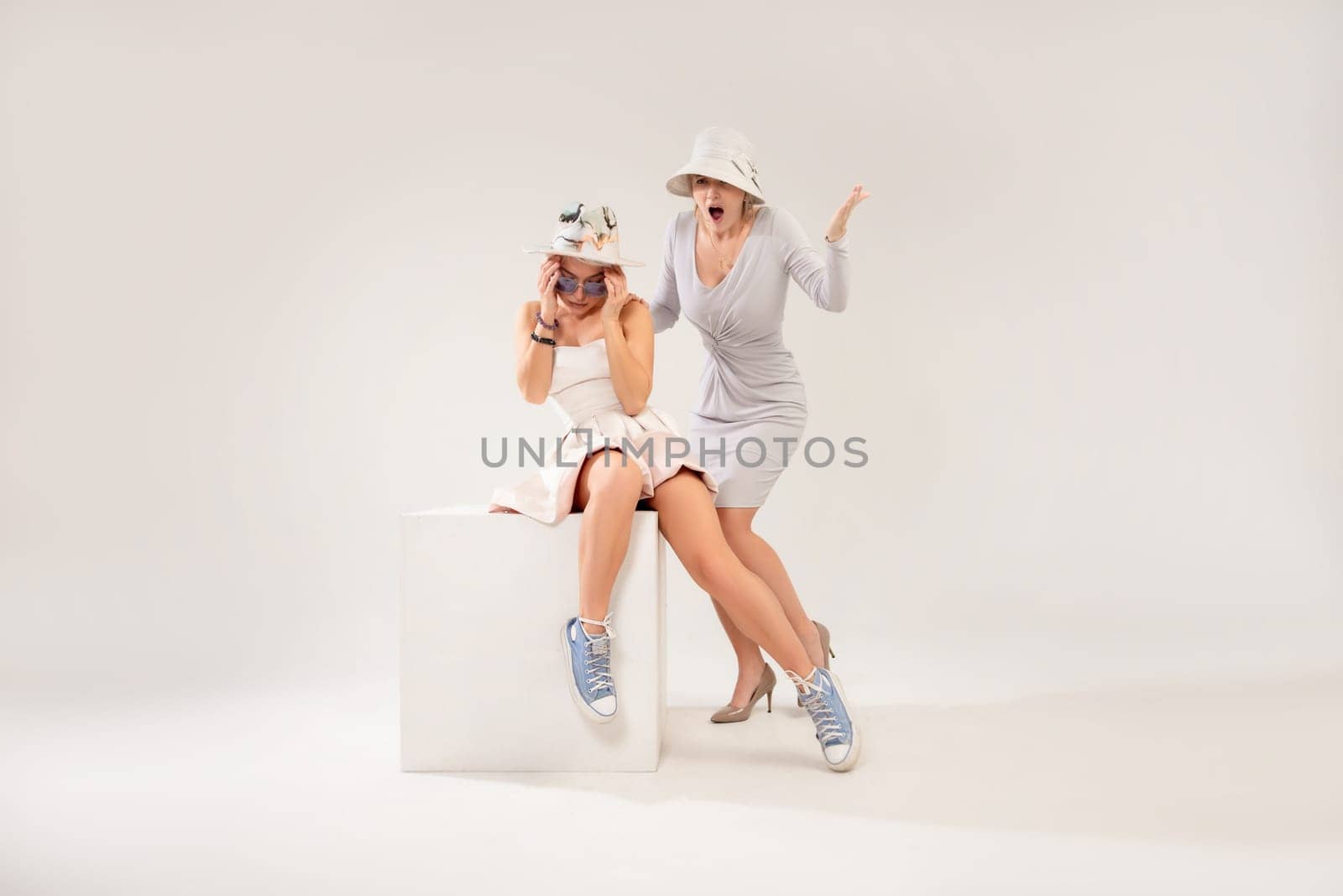 two girls in different styles of clothing playing a conflict or quarrel with each other on a white background, the psychology of human relations, the conflict of the inner child and parent by Rotozey