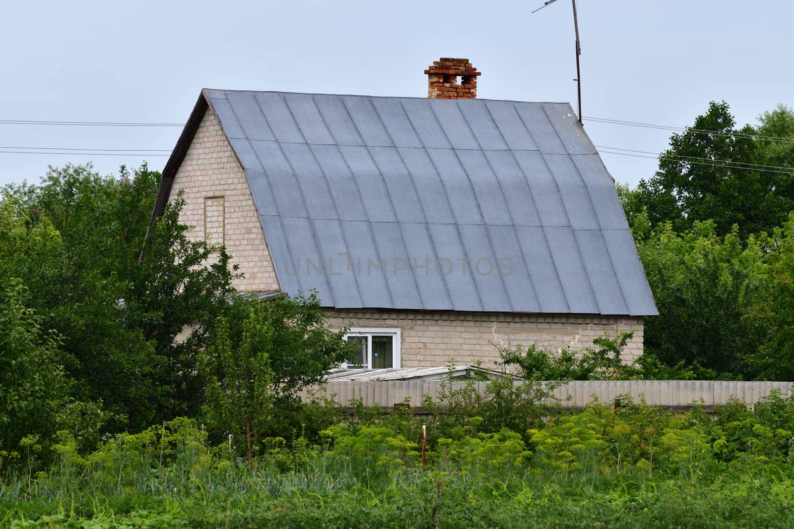 Rural house made of silicate brick with a metal roof, Russia