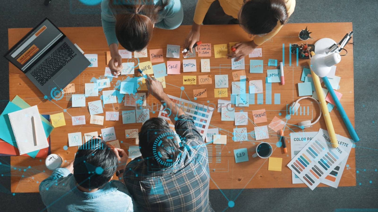 Top down view of business team with casual outfit looking laptop screen and sharing idea. Aerial view of manager works and checking color palette at table with statistic graph holographic. Symposium.