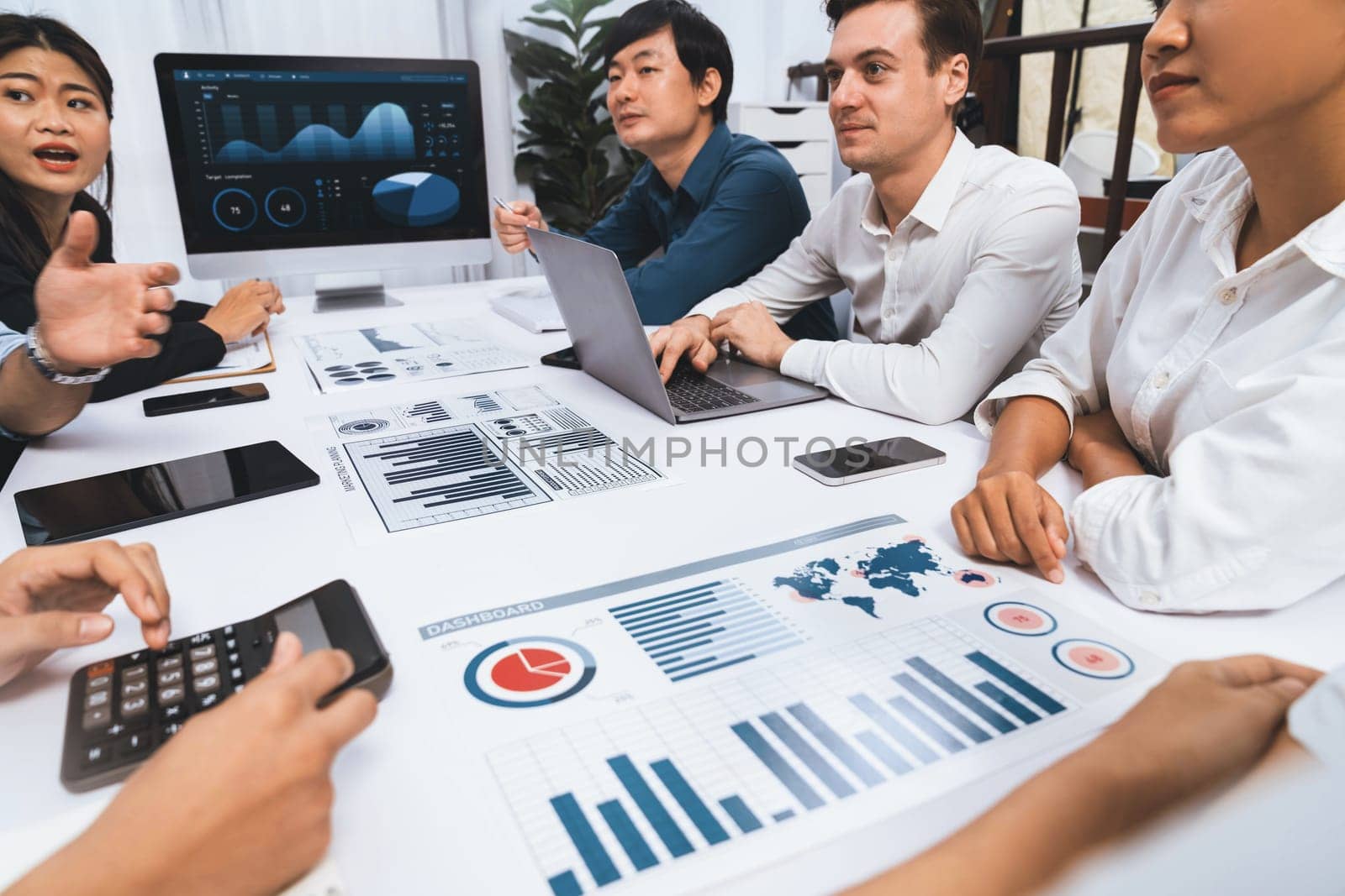 Analyst team utilizing BI Fintech to analyze financial data at table in meeting room. Businesspeople analyzing BI dashboard power for business insight and strategic marketing planning. Prudent