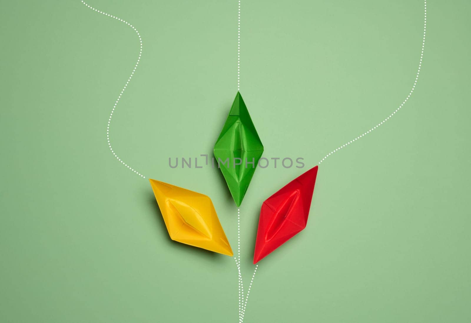 Paper boats on a green background with paths of movement, representing the concept of individuality by ndanko