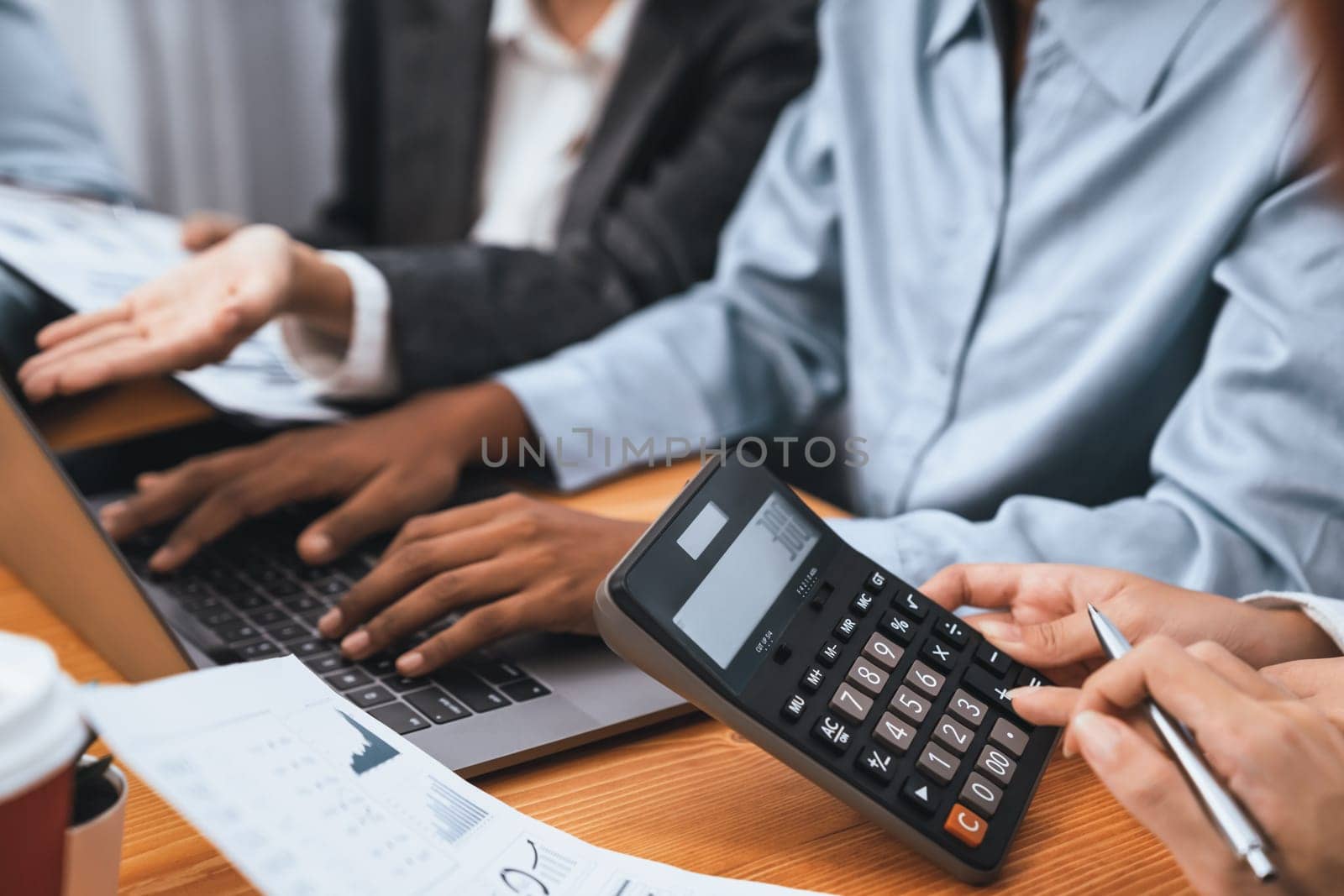 Multiracial analyst team use calculator and data science BI Fintech dashboard data to analyze financial report on office meeting table. Diverse business people for analytic teamwork. Concord