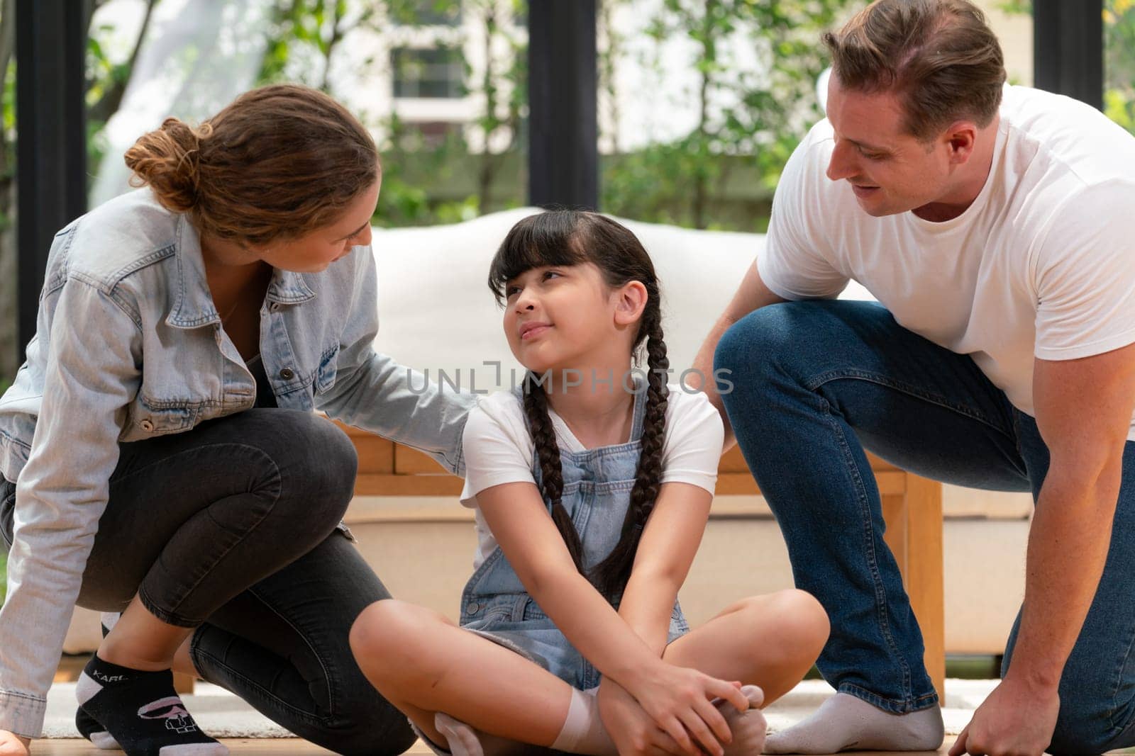 Parents comforting their daughter with loving embrace, helping her feel secure and protected as she rest her head on their shoulder. Happy family love and child care support concept. Synchronos