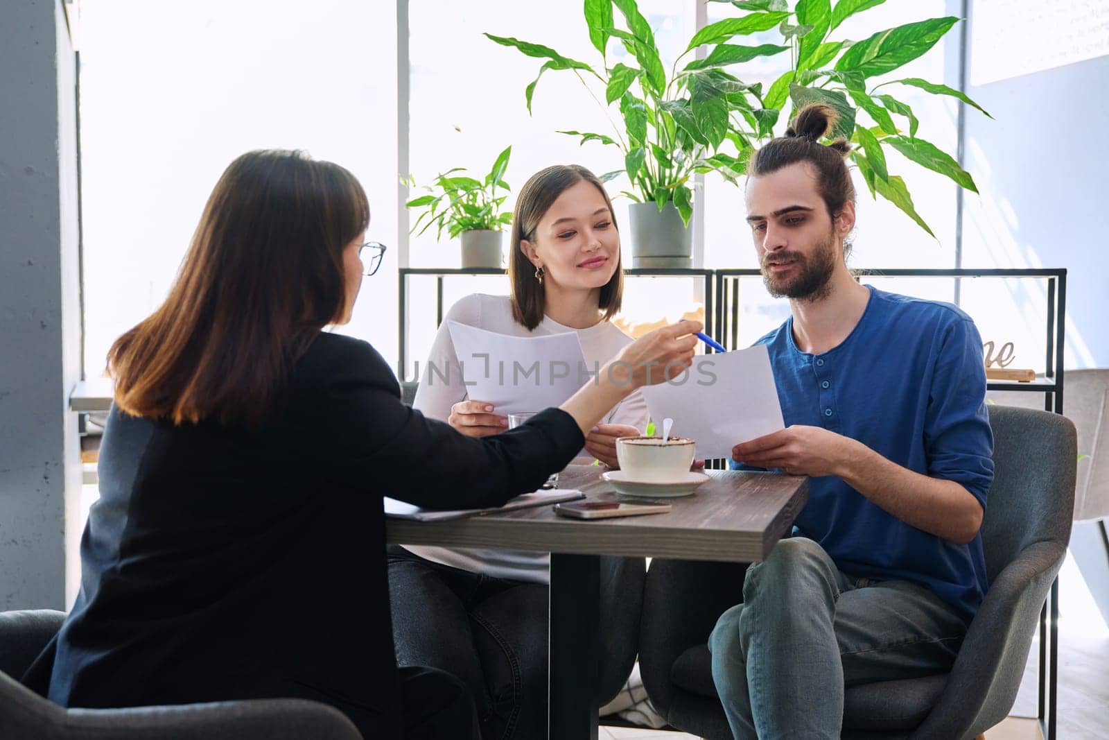 Female psychologist, counselor talking and working with young couple by VH-studio