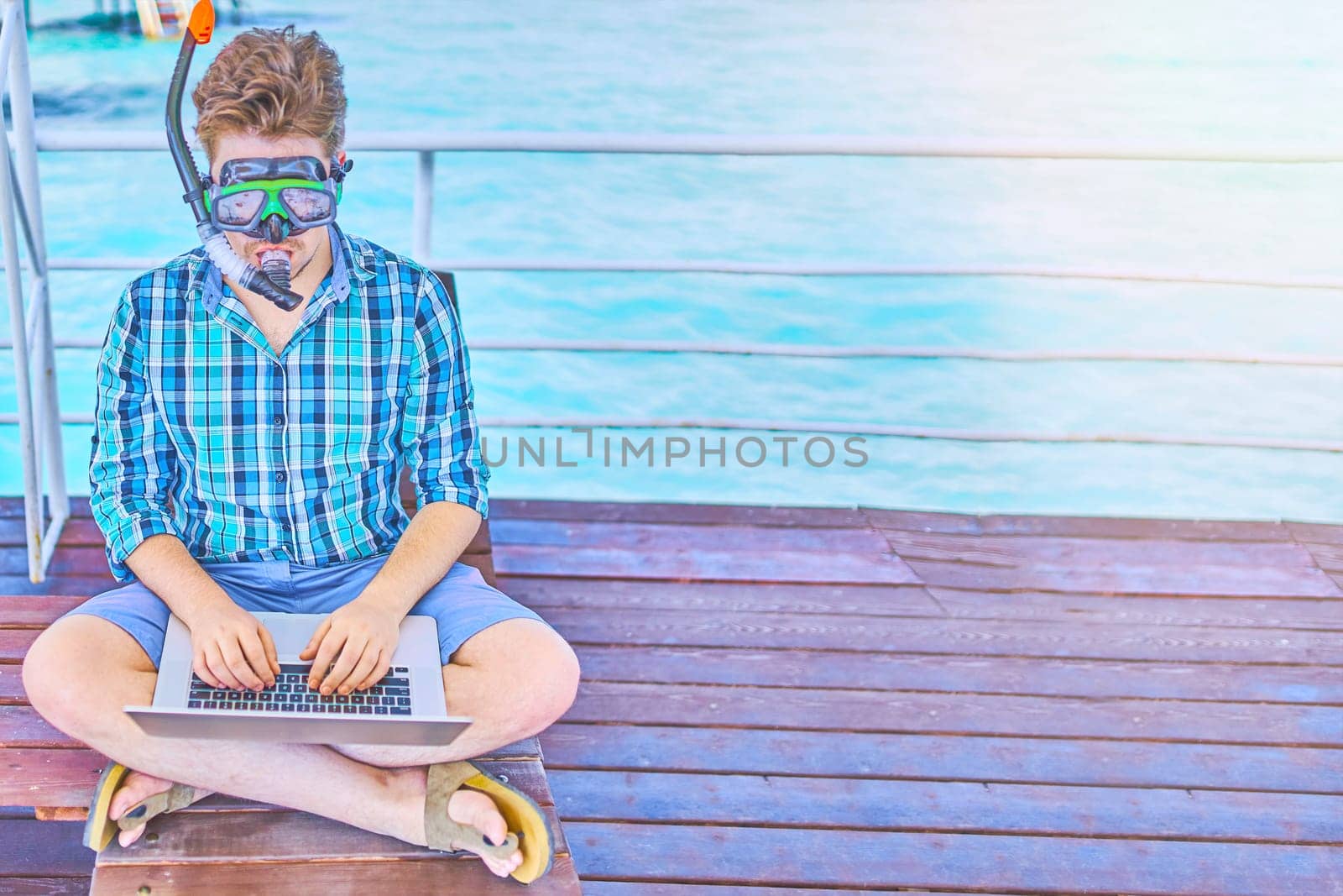 A man in an underwater mask, working on vacation.