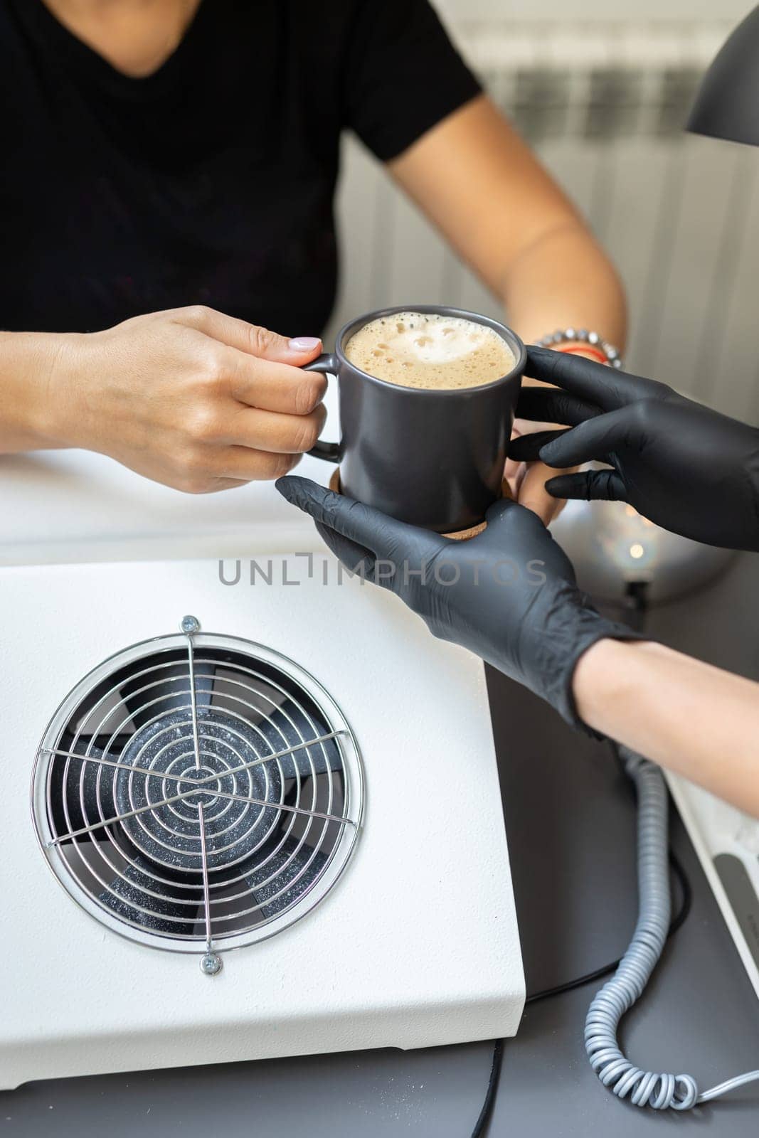 Small business, people and service concept - woman giving coffee cup customer at manicure salon.