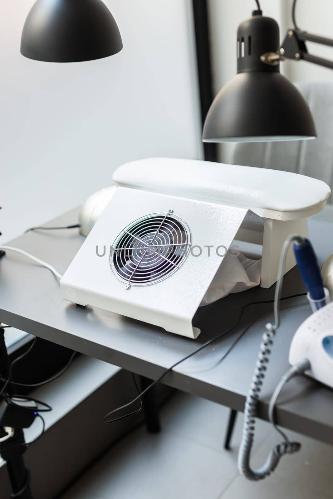 Modern table with nails color palette and lamp situating in salon. Workplace for manicure. Interior concept. by Satura86