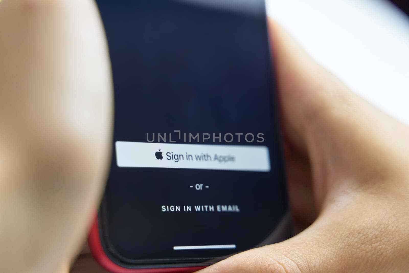 Bishkek, Kyrgyzstan - June 6, 2019: Sign in with Apple Button for your privacy. Man holds a smartphone and authorizes the Internet service