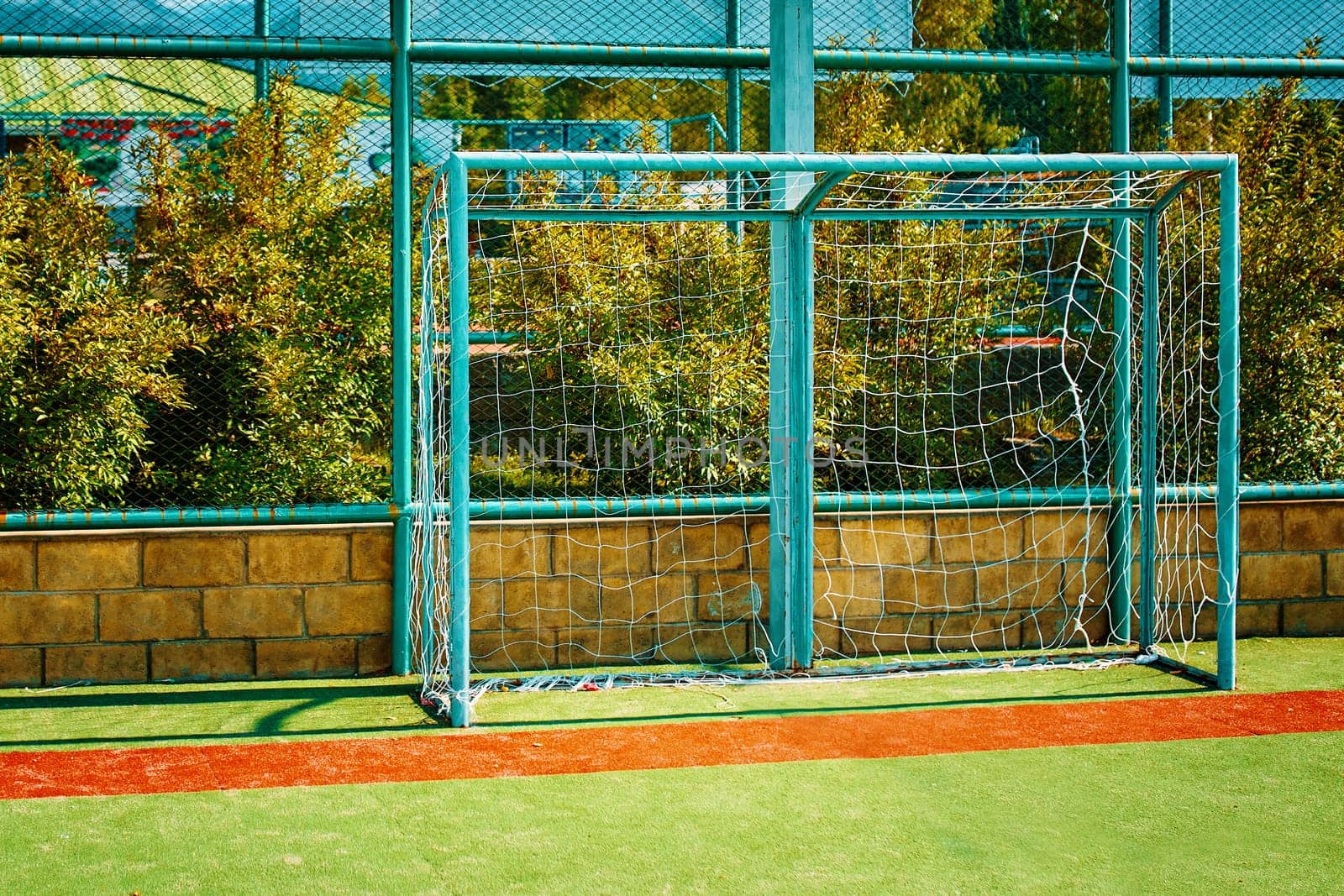 Goal in green color for mini football on an artificial grass field