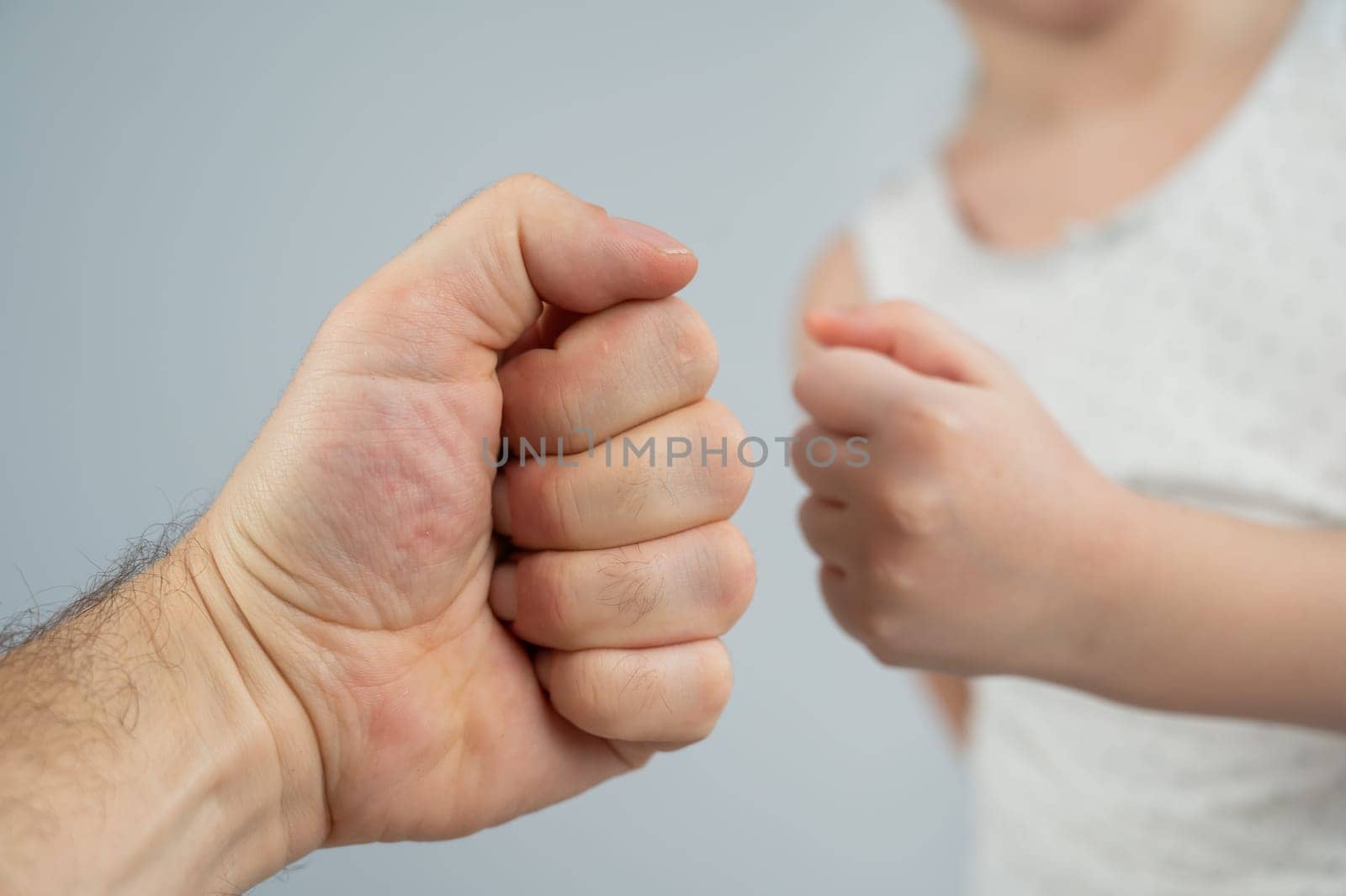 Little Caucasian girl fist bumping with dad on white background