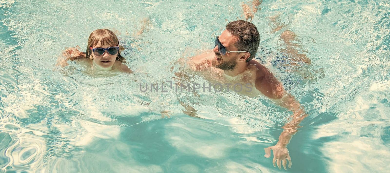 Father and son in swimming pool, banner with copy space. happy family of dad and kid having fun in summer swimming pool, summer holiday by RedFoxStudio