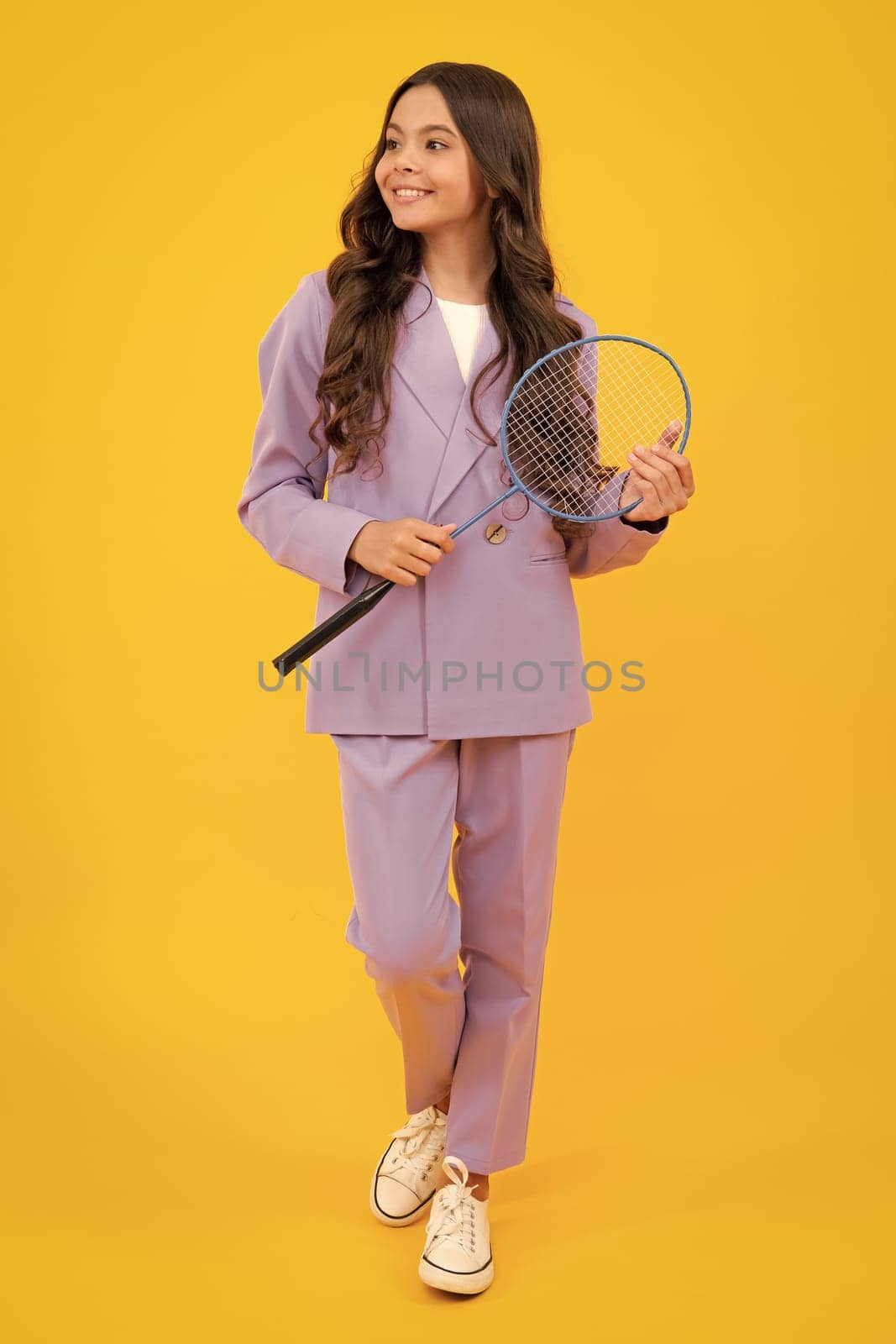 Teen girl badminton player in suit with badminton racket isolated on yellow background. by RedFoxStudio