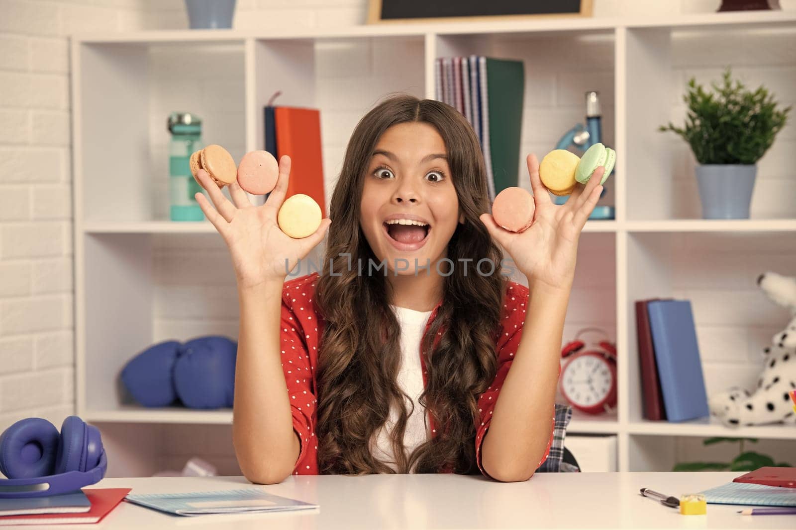 Child eat french macaron or macaroon cookies, macaroons. Excited face, cheerful emotions of teenager girl