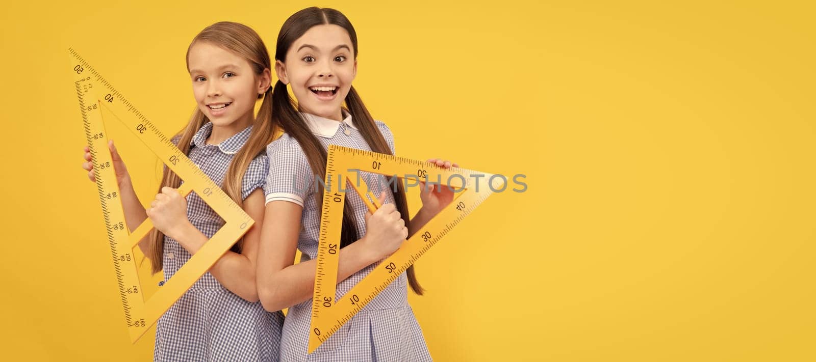 School girls friends. Happy teen girls hold triangular rulers. School education. Geometry lesson. Banner of school girl student. Schoolgirl pupil portrait with copy space. by RedFoxStudio